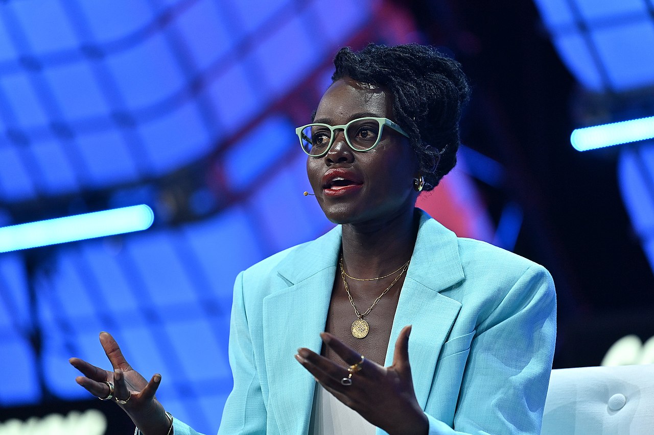 Lupita Nyong’o speaking on stage at Collision Conference during a panel on technology, storytelling, and Super Sema.