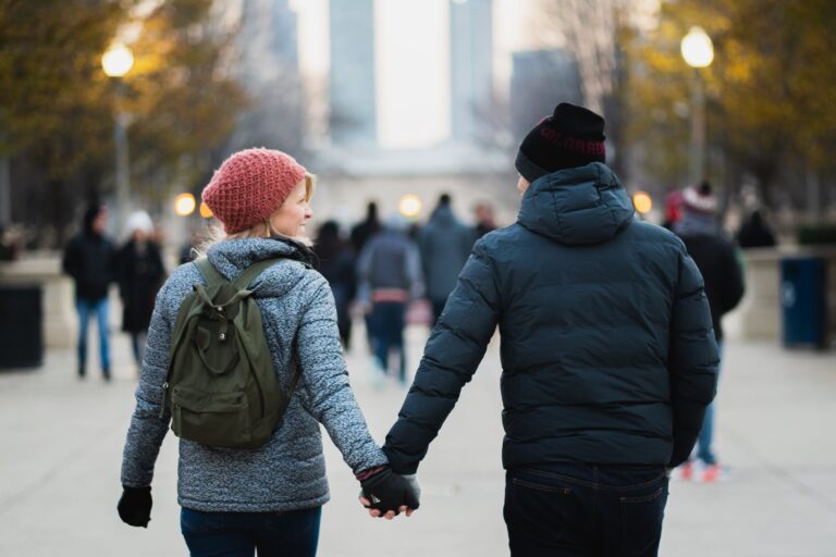 Love on the Road: The DG Speaks - Dating as a Digital Nomad - A romantic photo of a couple holding hands while traveling, symbolizing unity and shared exploration against a picturesque background.