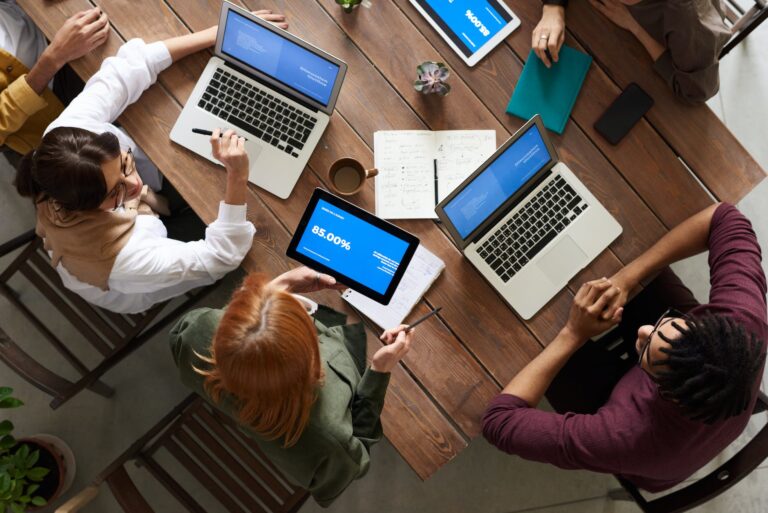 DG Speaks - Money - Consulting - Business Growth and Development - Top view photo of group of people using macbook while discussing