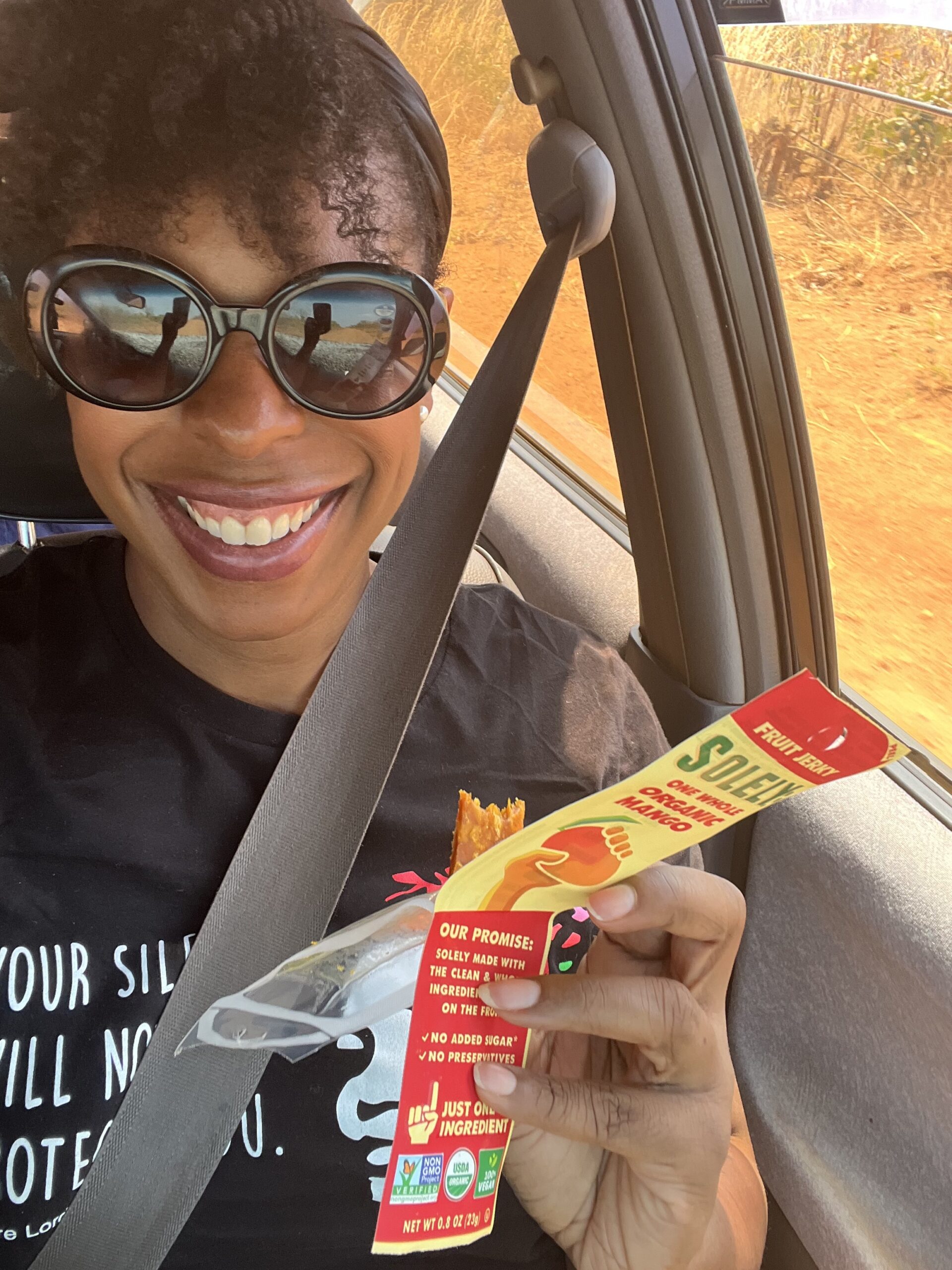 DG Speaks - Money - Food Consulting - Marketing - Mercedes smiling with a half-eaten Solely Mango bar during a car ride in Zambia.