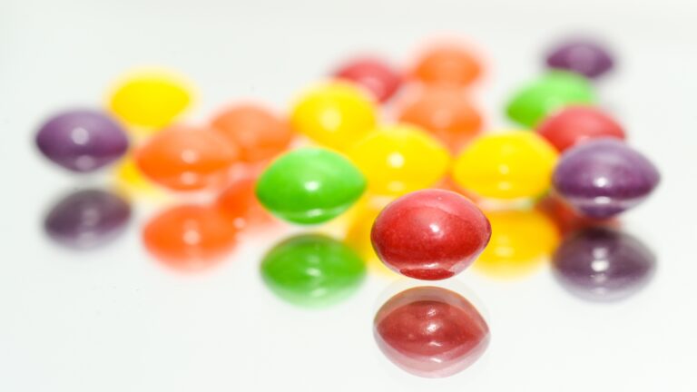 Skittles scattered out against a white background.