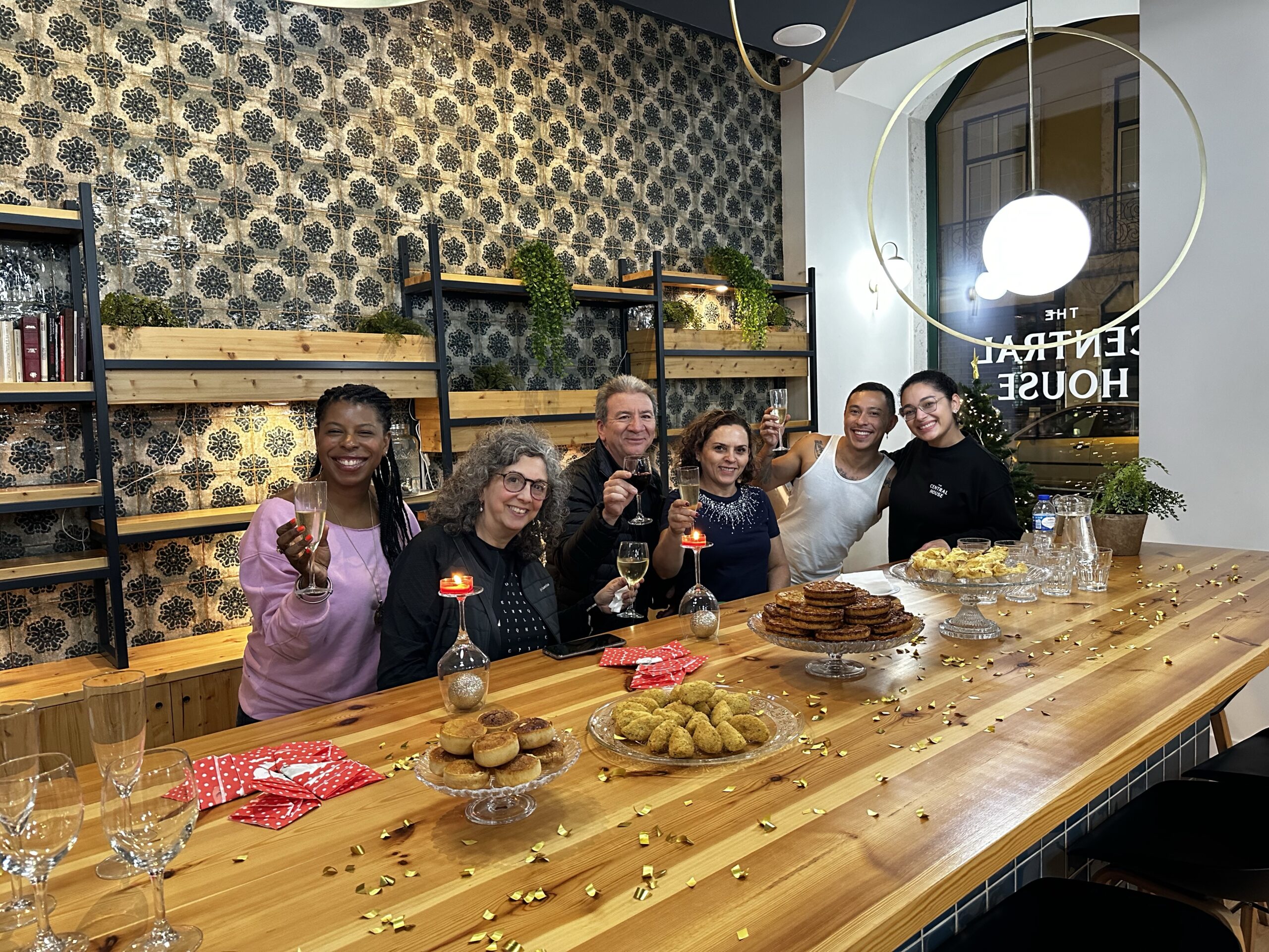 DG Speaks - Travel - Image of Mercedes and a group joyfully celebrating the end of 2023 at a Lisbon hostel, capturing the festive spirit and camaraderie of New Year’s Eve.