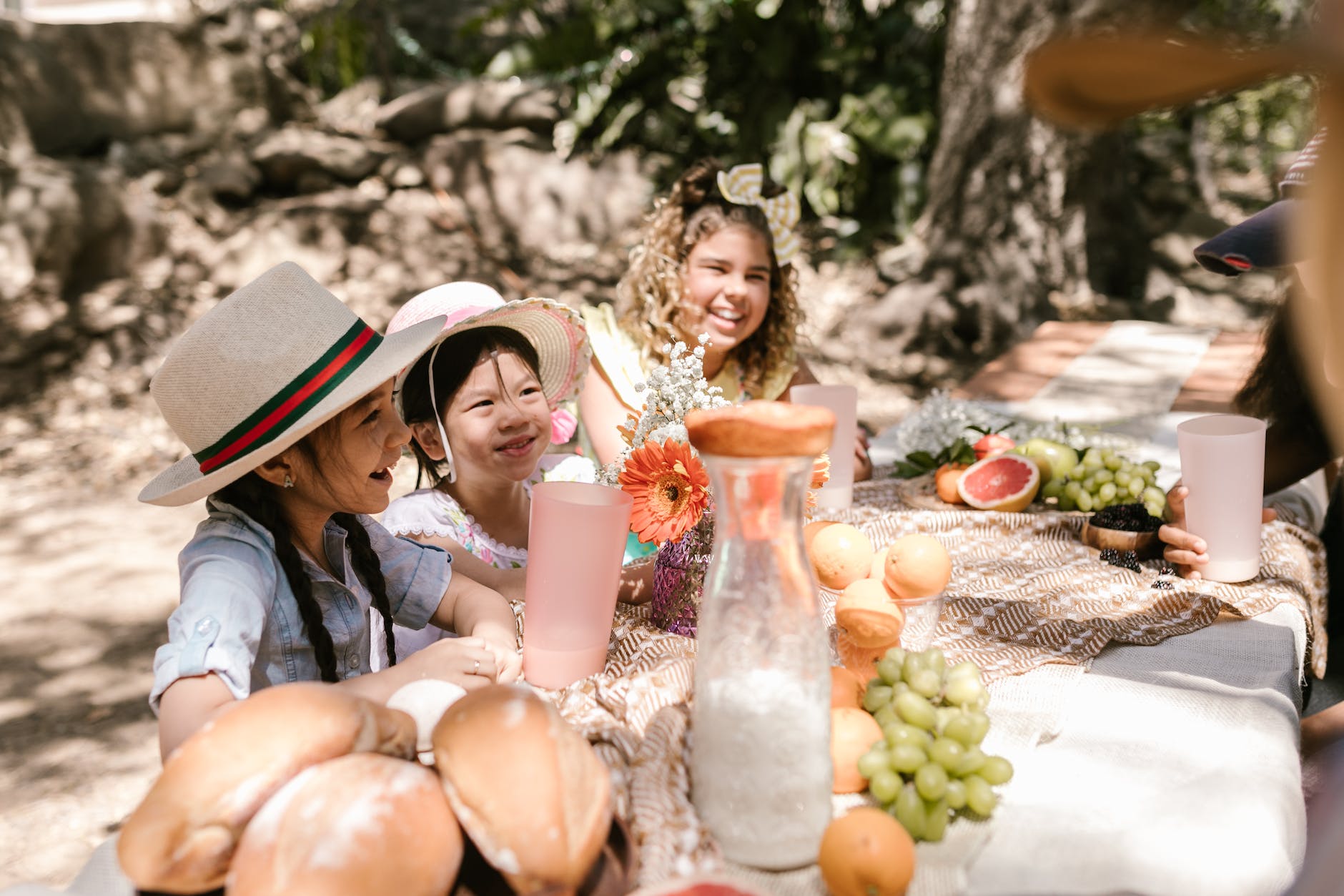 DG Speaks - Lifestyle - Sustainable Southern Table - Children gathered around a table in a serene yard, connecting with nature and each other in a peaceful setting.