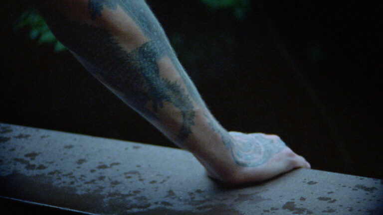 A still from Nido de Cocodrilo - Crocodile Nest, showing tattooed arms.