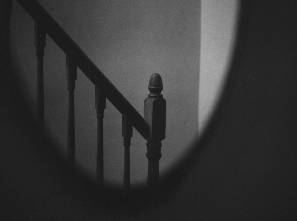 A still from Hexham Heads, showing a hauntingly staircase in a dark, mysterious setting.