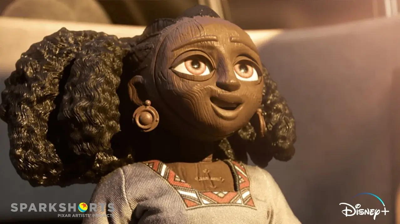 Wooden puppet character from Pixar’s Self (2024) smiling with hope, wearing a patterned dress, in warm sunlight.