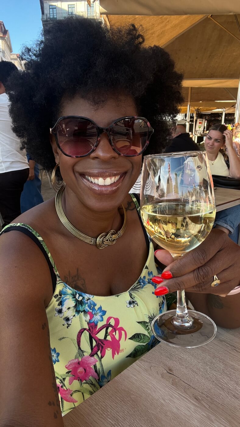 Mercedes holding a glass of wine and smiling in Porto