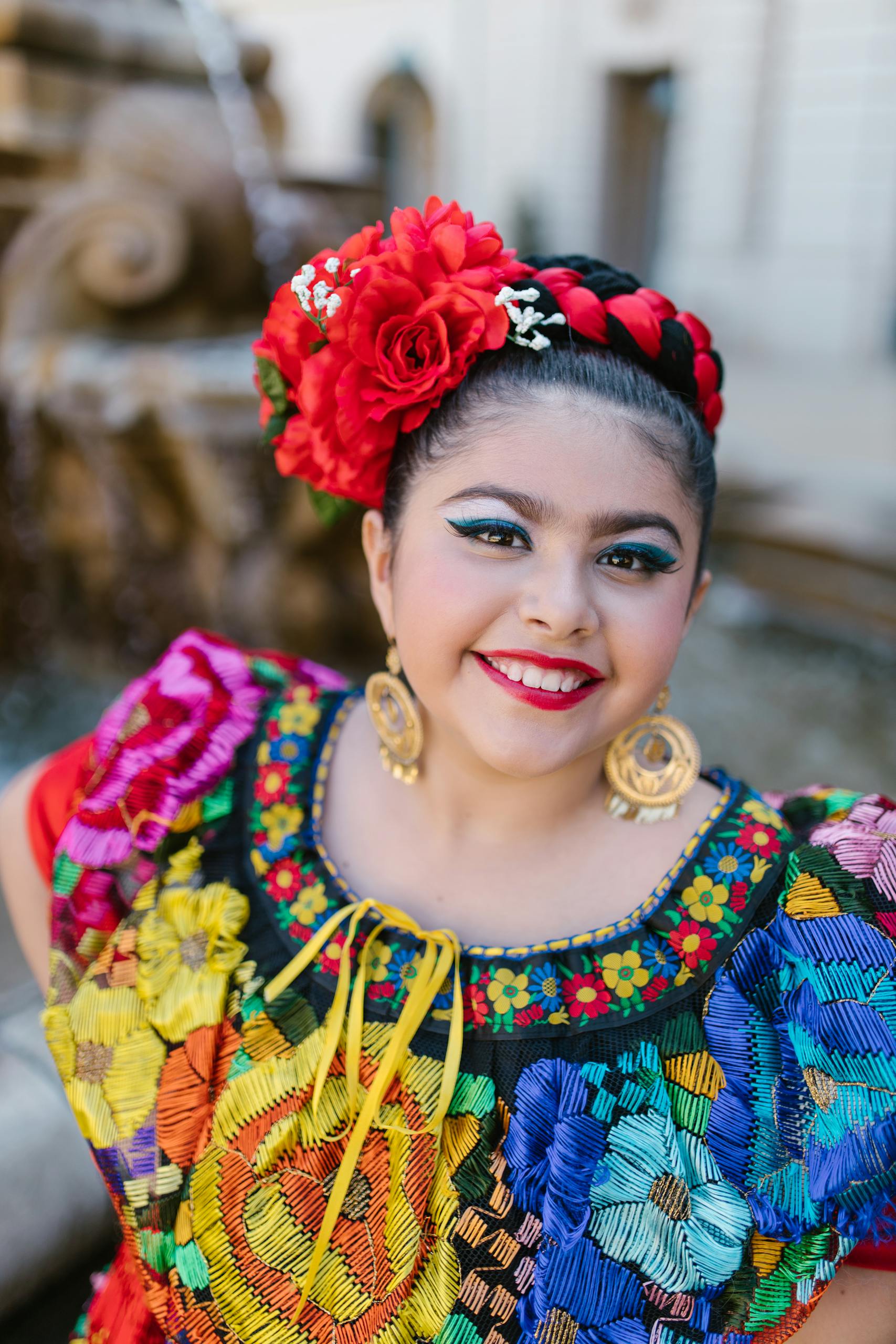 Cinco de Mayo. Portrait of a smiling woman wearing vibrant traditional Mexican attire outdoors.
