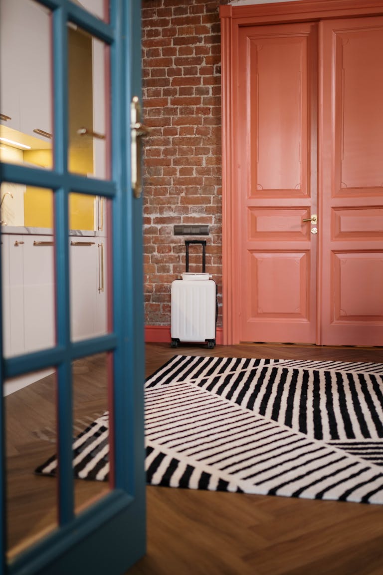 Airbnb hosting lessons - Stylish interior with modern decor and white suitcase by the door, featuring vibrant colors.