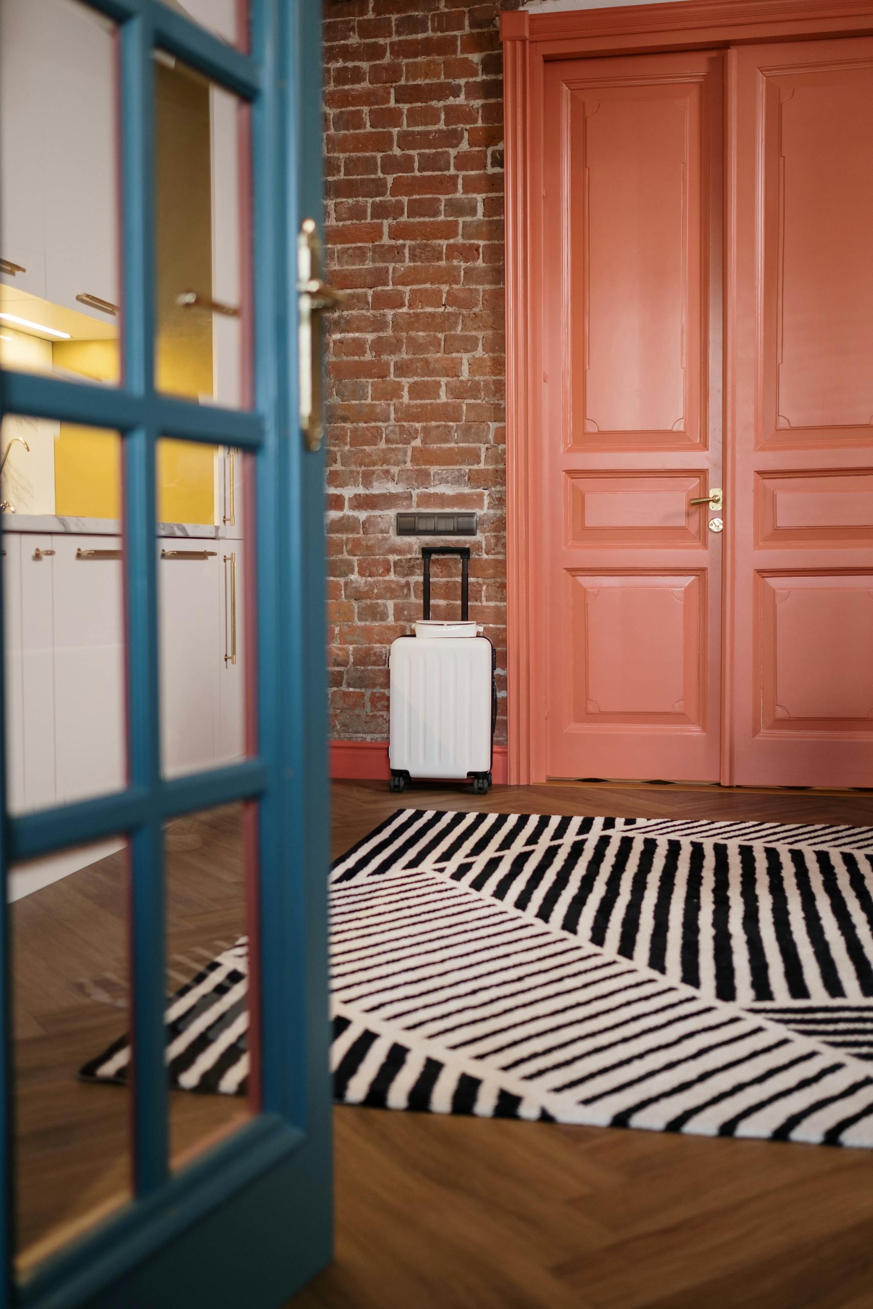 Airbnb hosting lessons - Stylish interior with modern decor and white suitcase by the door, featuring vibrant colors.