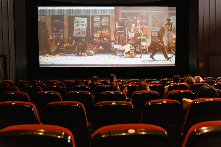 A cozy indoor movie theater showing an animated film to a small audience. TIFF