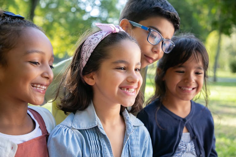 The Kids Are Alright - Happy children smiling together outdoors on a sunny day.