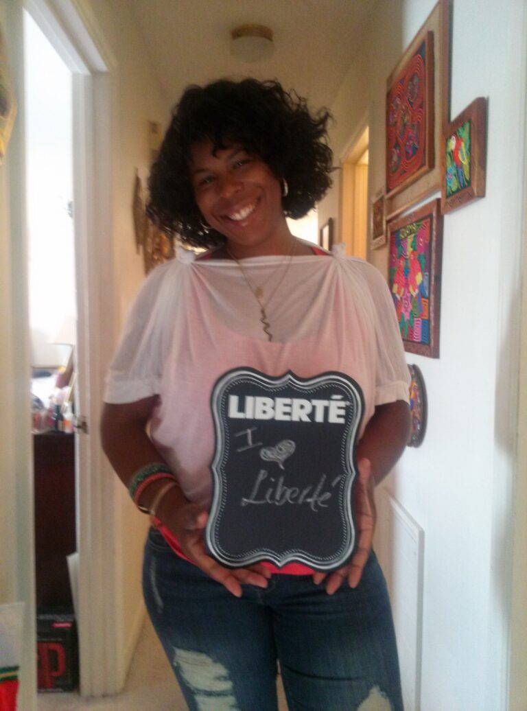 Mercedes Diane Griffin Forbes smiling while holding a chalkboard reading “I Love Liberté” during her time as a Liberté Yogurt brand ambassador, reflecting early wellness culture, lifestyle branding, and food identity in the 2010s.