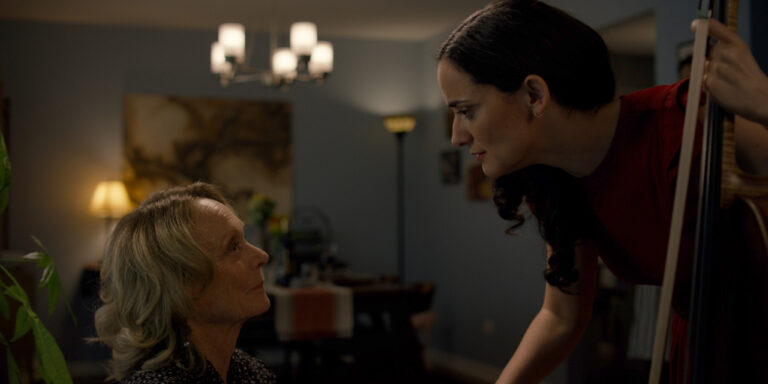 Actress playing cello beside older woman during an emotional scene in The Birthday Gift short film