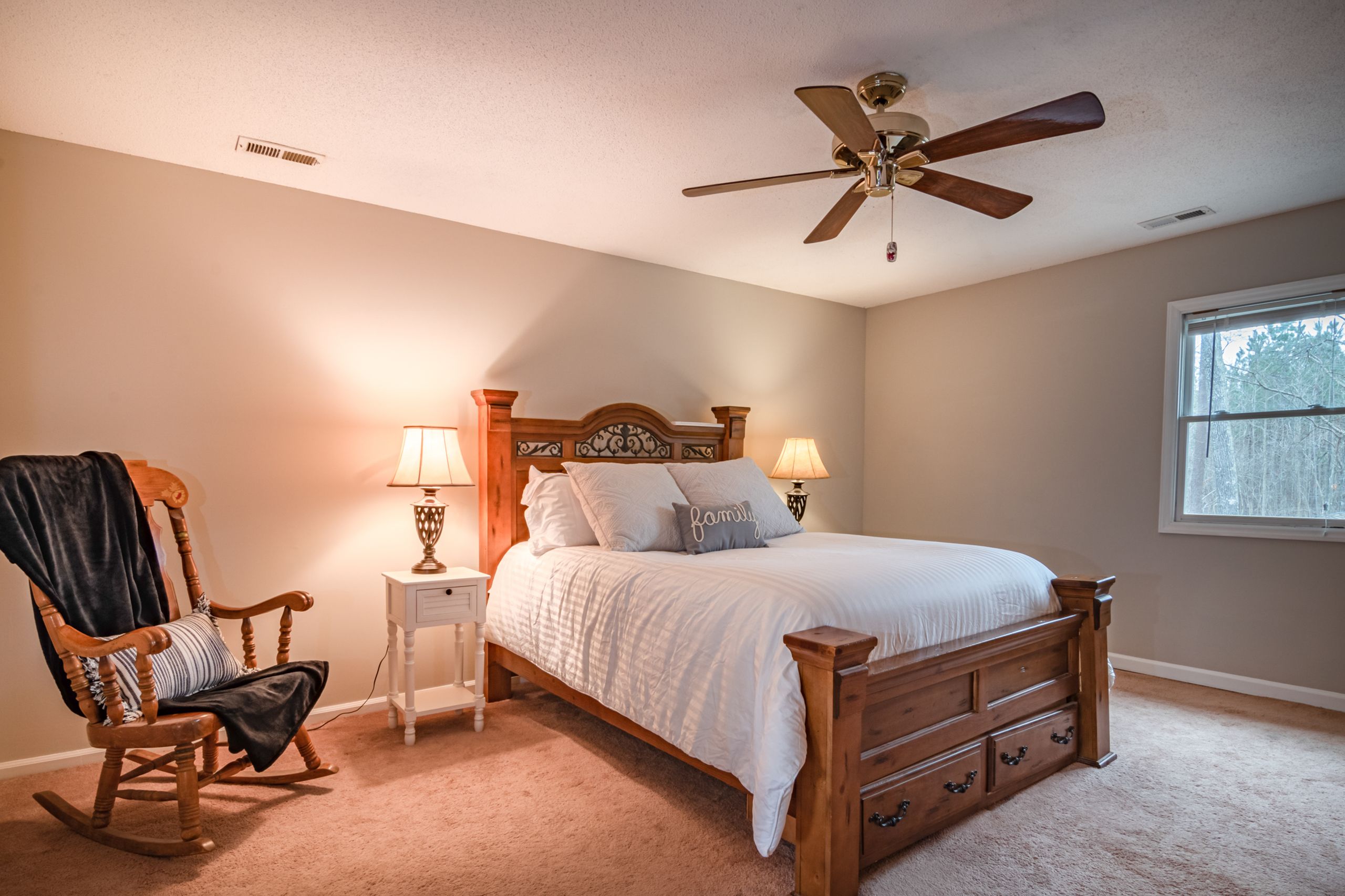 Airbnb Bedroom Essentials: How to Create a Comfortable Space Guests Will Remember - Warm and inviting bedroom featuring a wooden bed, ceiling fan, and cozy decor.