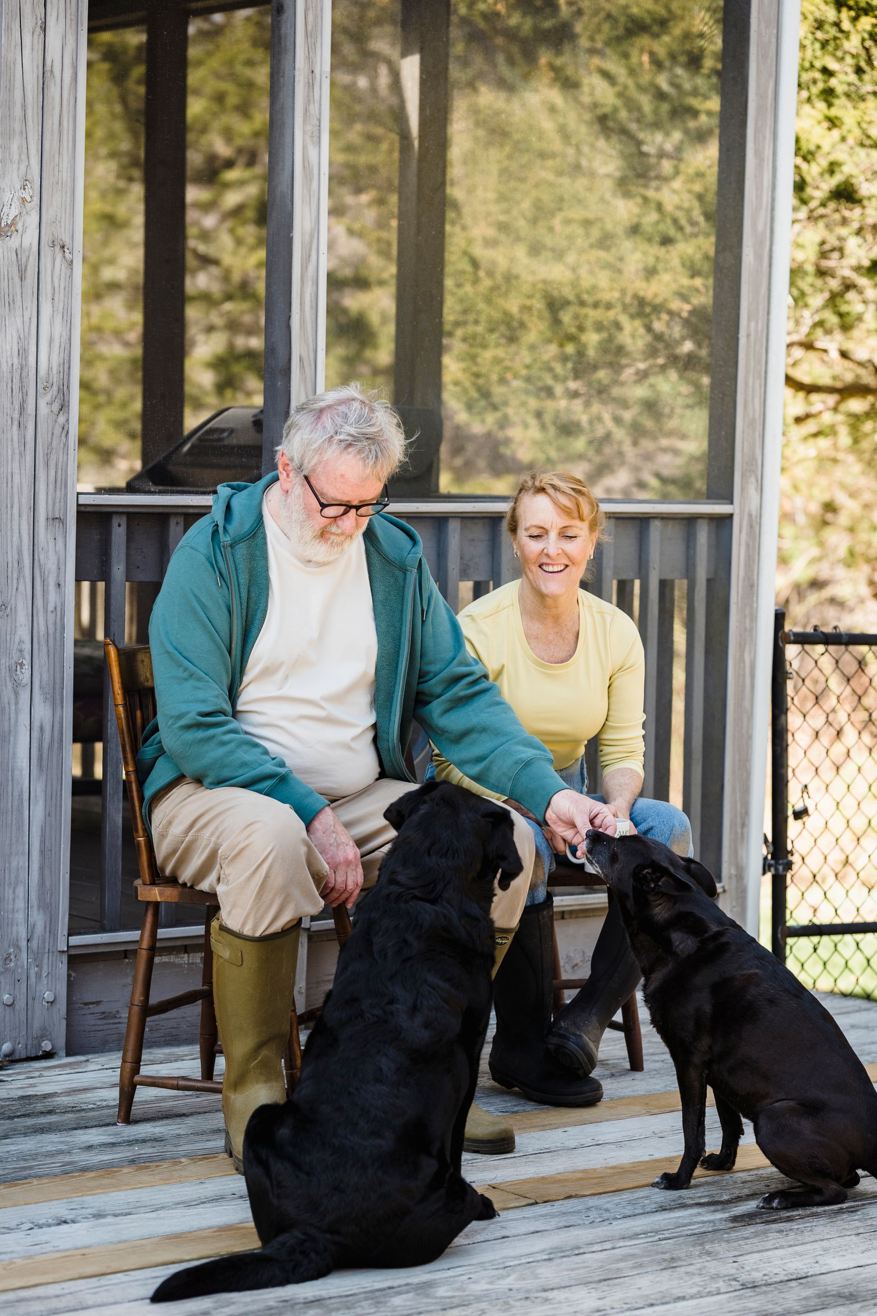Airbnb Guest Reviews: How to Earn More Five-Star Reviews Naturally -Senior couple seated outside with their two dogs, enjoying a sunny day on the porch.
