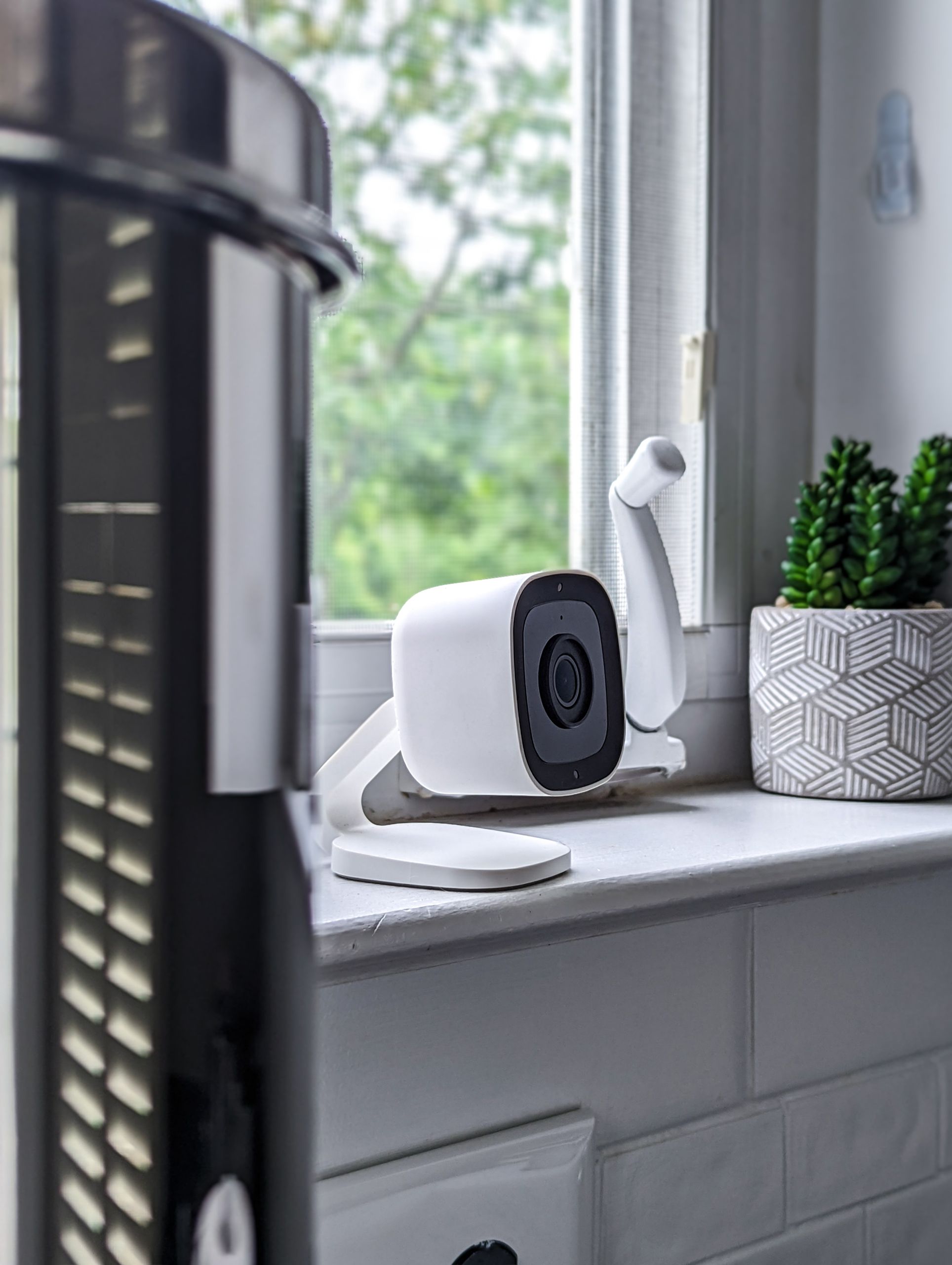 Airbnb Security Tips: Simple Ways to Protect Your Home and Your Guests - A sleek white security camera placed on a windowsill in a modern home setting, highlighting technology indoors.