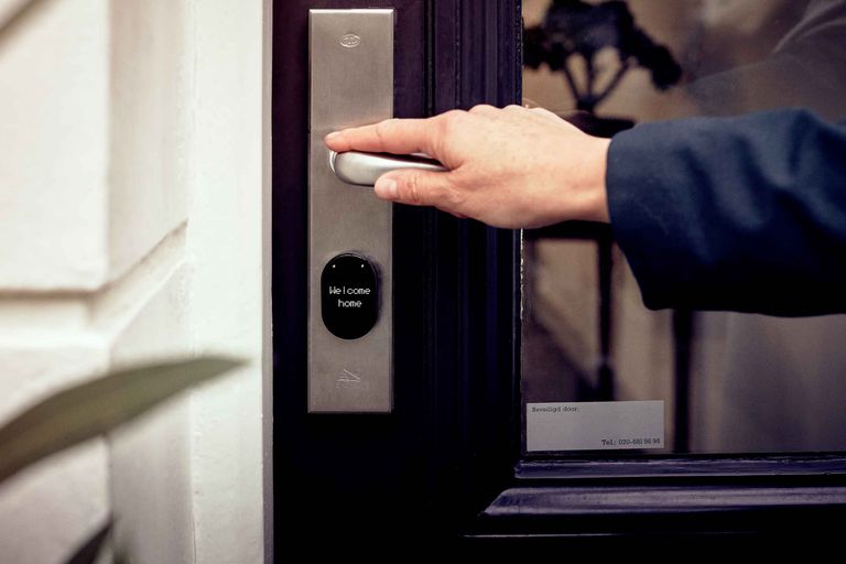 Airbnb Self Check-In: Why Guests Love It and How to Set It Up Successfully - A hand opening a smart home door with digital access panel, conveying security and technology.