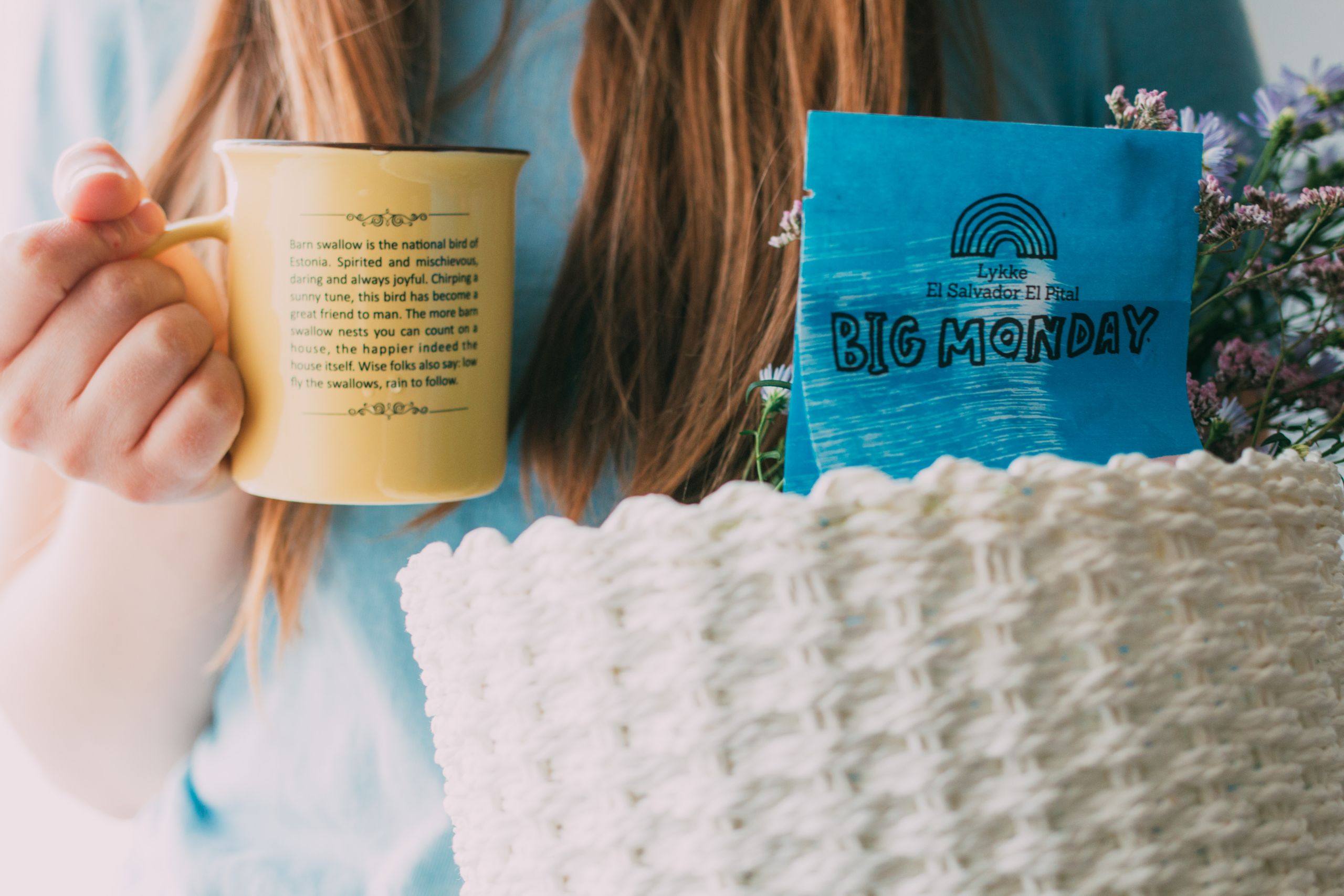 Airbnb Welcome Basket Ideas: Simple Touches That Turn Guests into Repeat Visitors - Close-up of a woman holding a mug and a basket with flowers and a gift.