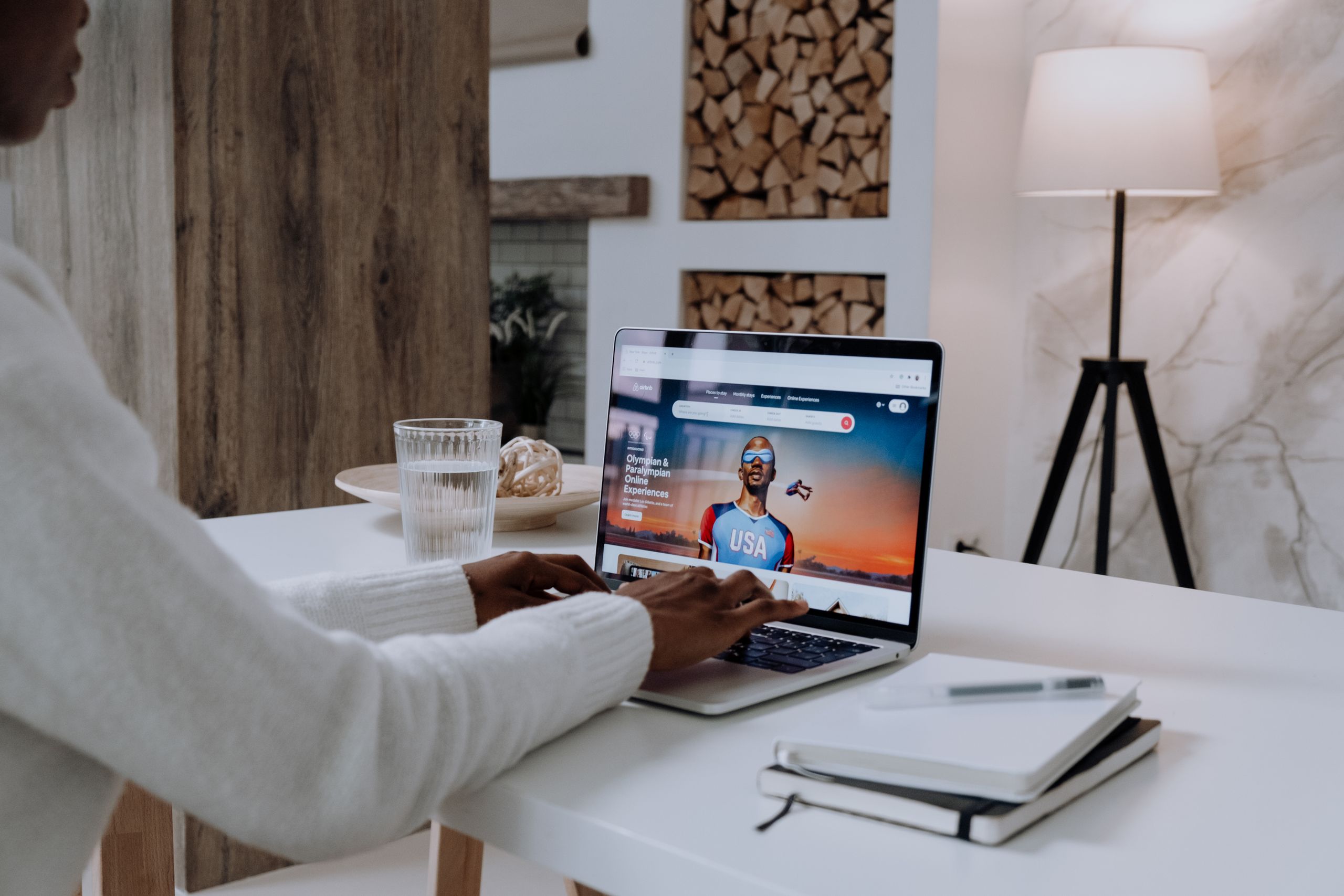 Airbnb Wi-Fi: Why Fast Internet Can Increase Your Bookings - Faceless person using a laptop with online content in a cozy modern setting.