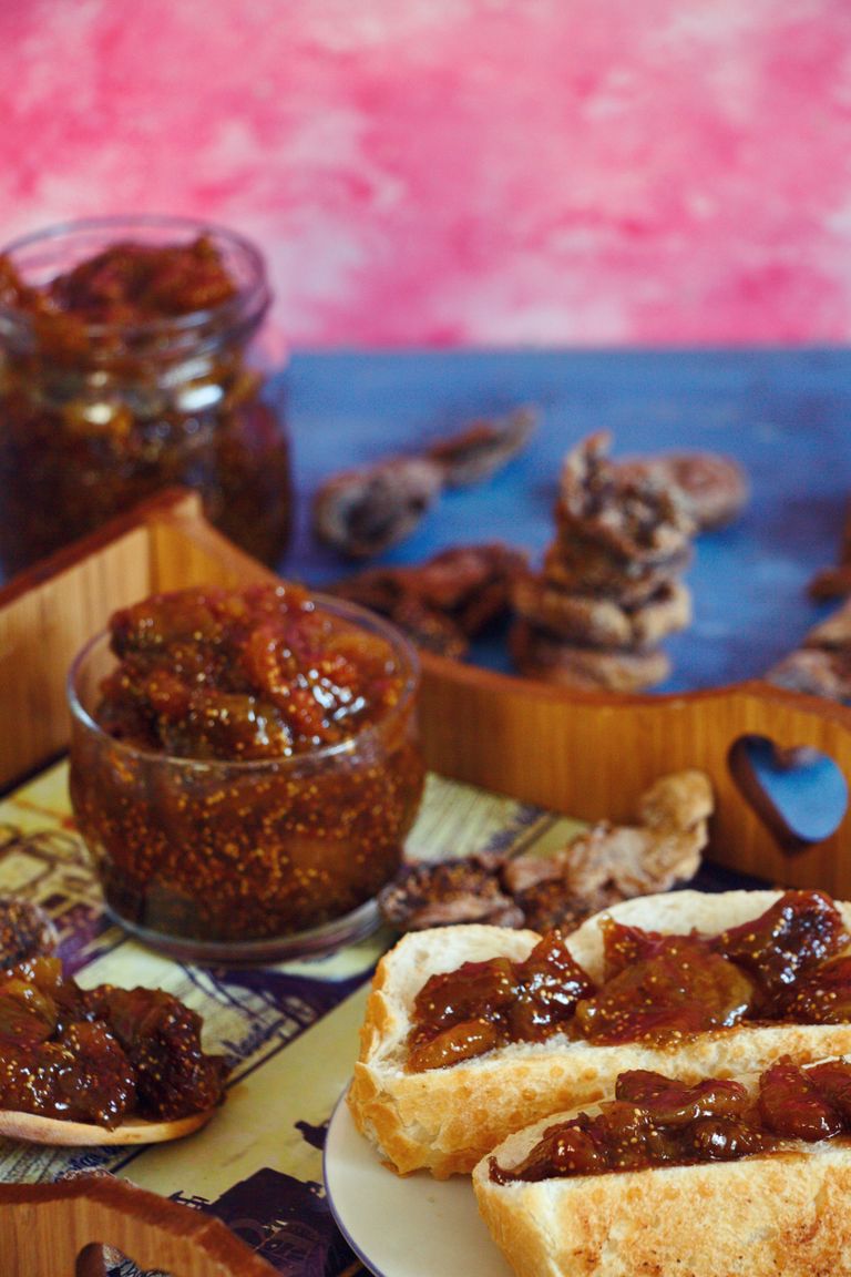 Close-up of fig jam in a bowl and spread on bread slices, perfect for a delicious breakfast.