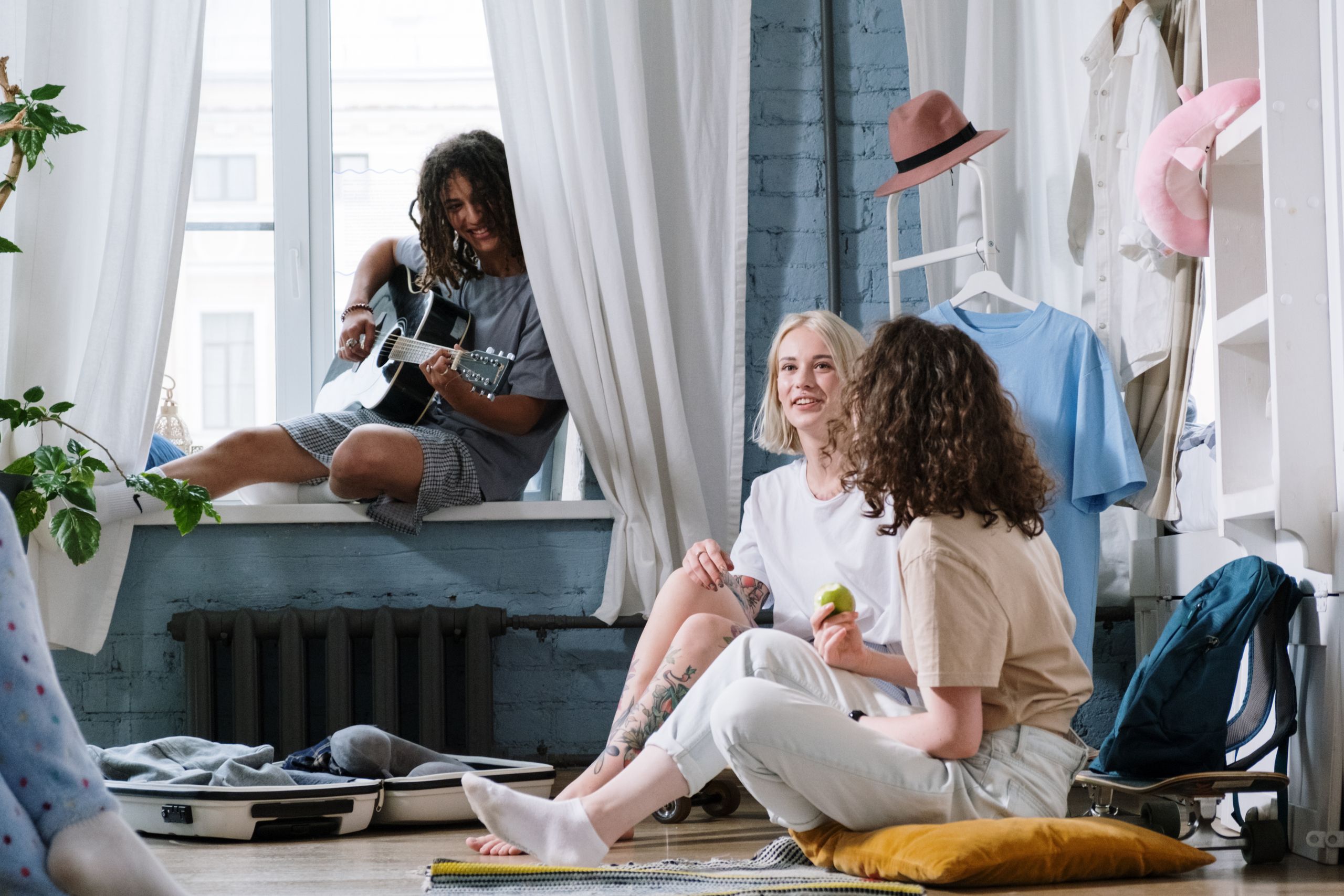 Shared Airbnb Experience: A Guide for First-Time Guests - Cozy indoor scene with friends playing guitar and relaxing, capturing a sense of companionship.