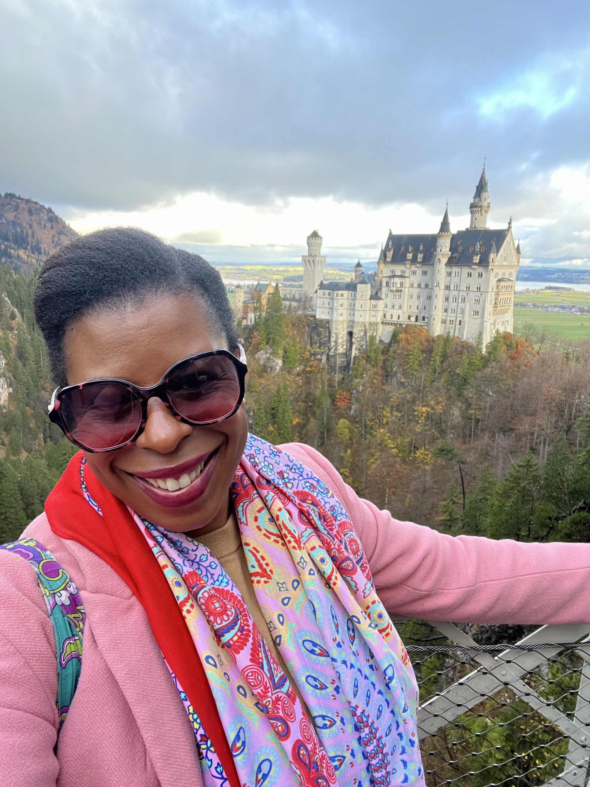 Black woman traveler at Marienbrücke with Neuschwanstein Castle behind her