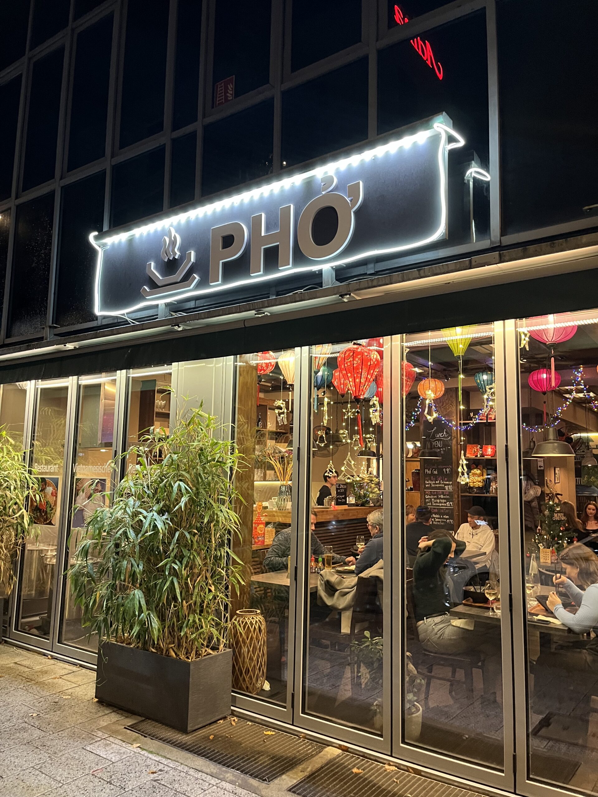 Illuminated PHO Vietnamese restaurant storefront in Nuremberg