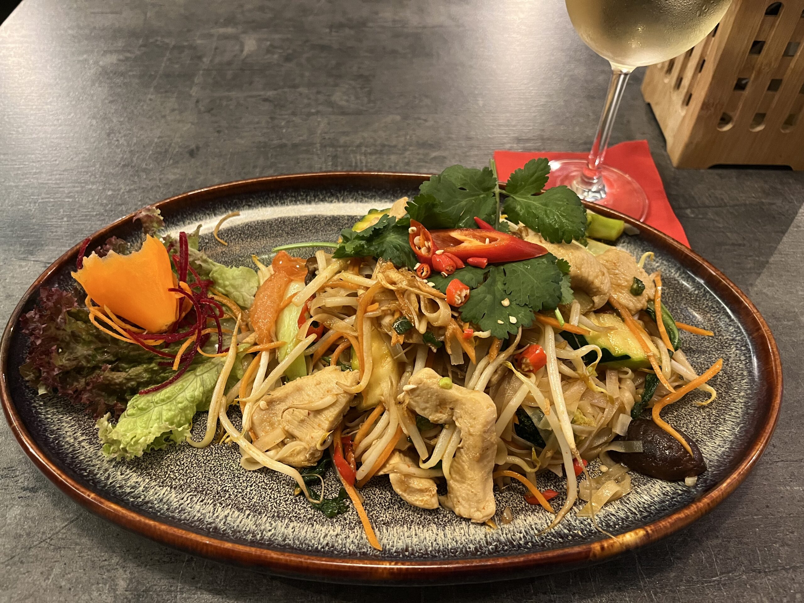 Vietnamese stir-fried noodles with chicken vegetables herbs and chili in Nuremberg