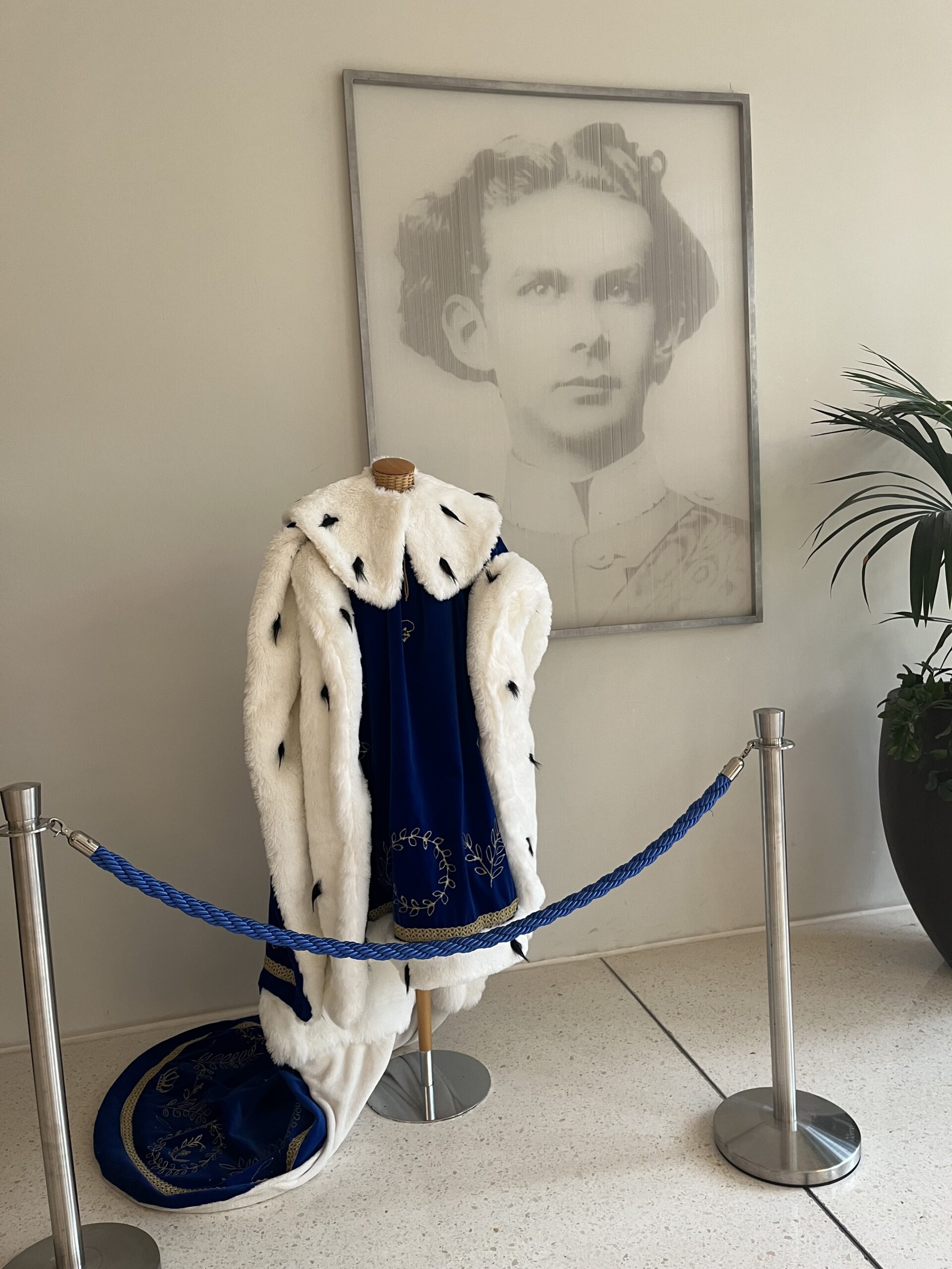 Blue ceremonial robe beneath a portrait of King Ludwig II