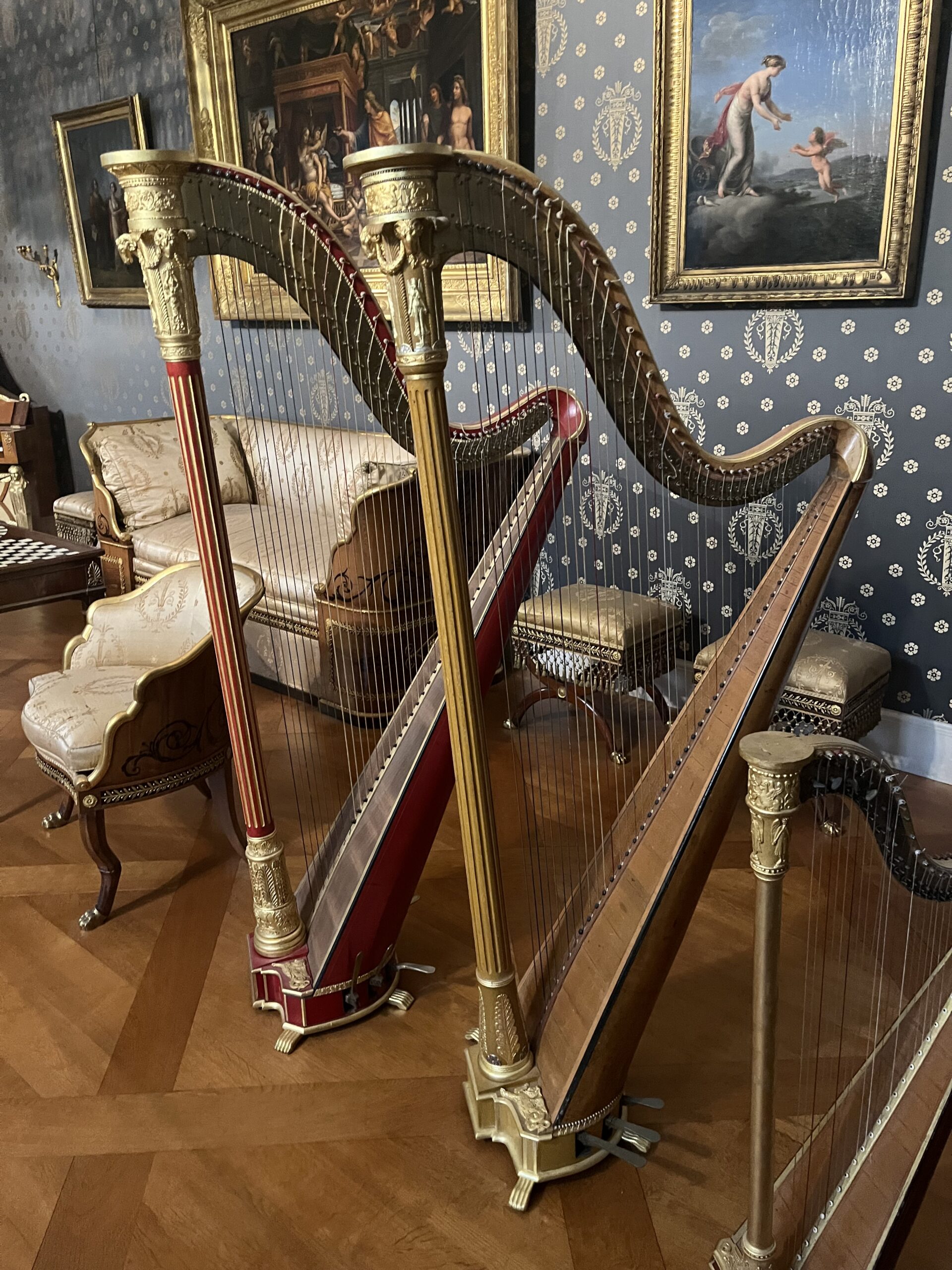 Three ornate historic harps inside the Munich Residenz