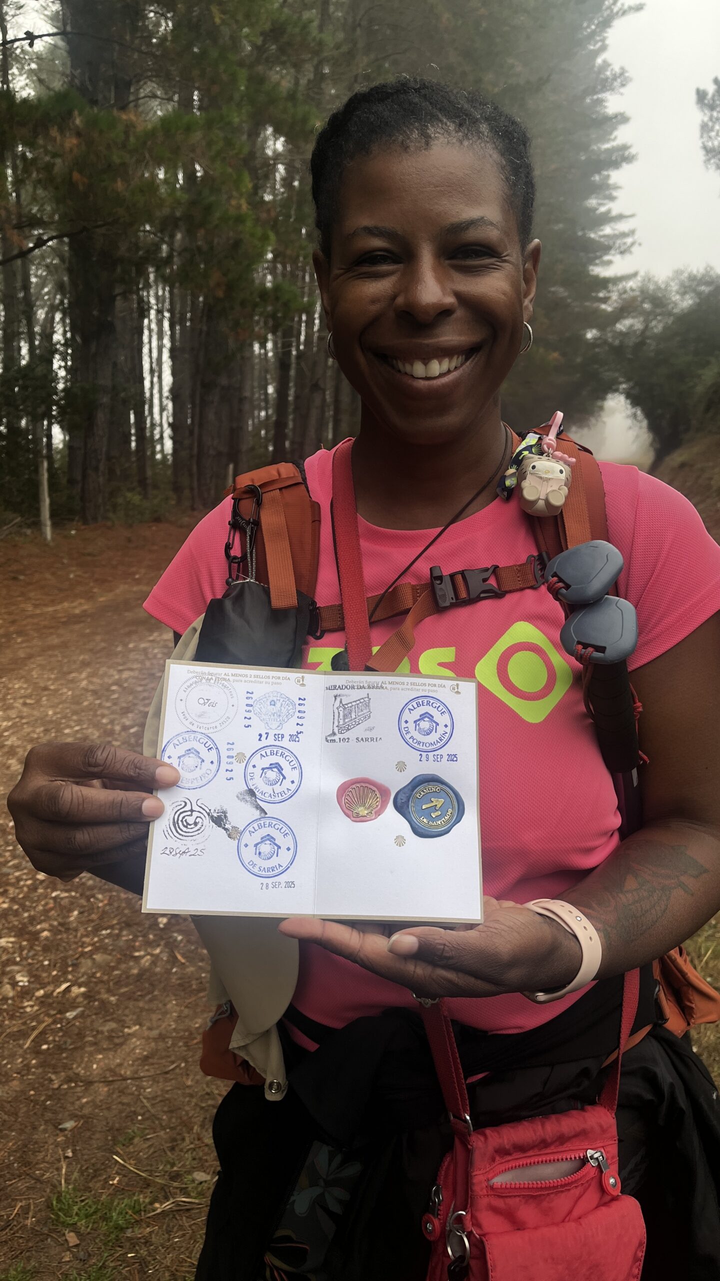 Camino Budget Guide: What to Expect and Where to Save - Mercedes holding her Camino passport showing the stamps she's earned on the trail