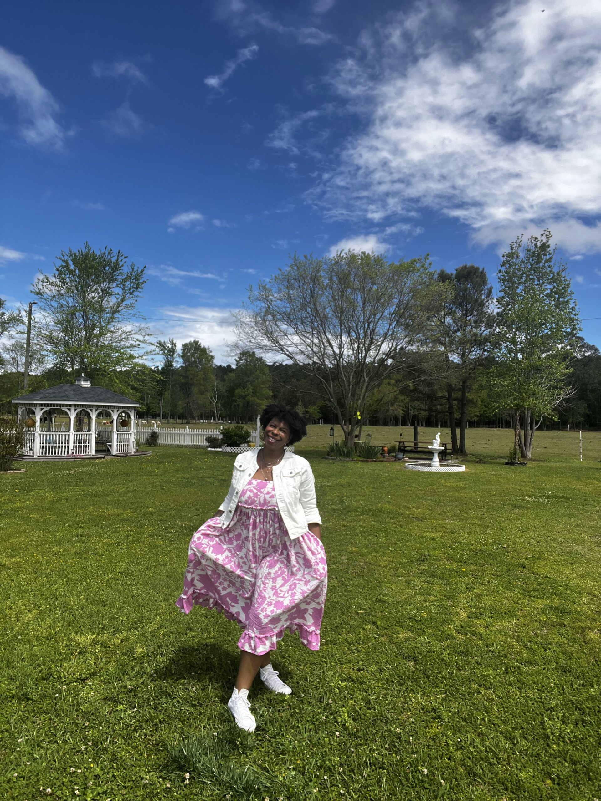 Mercedes joyfully walking outside in pink dress.