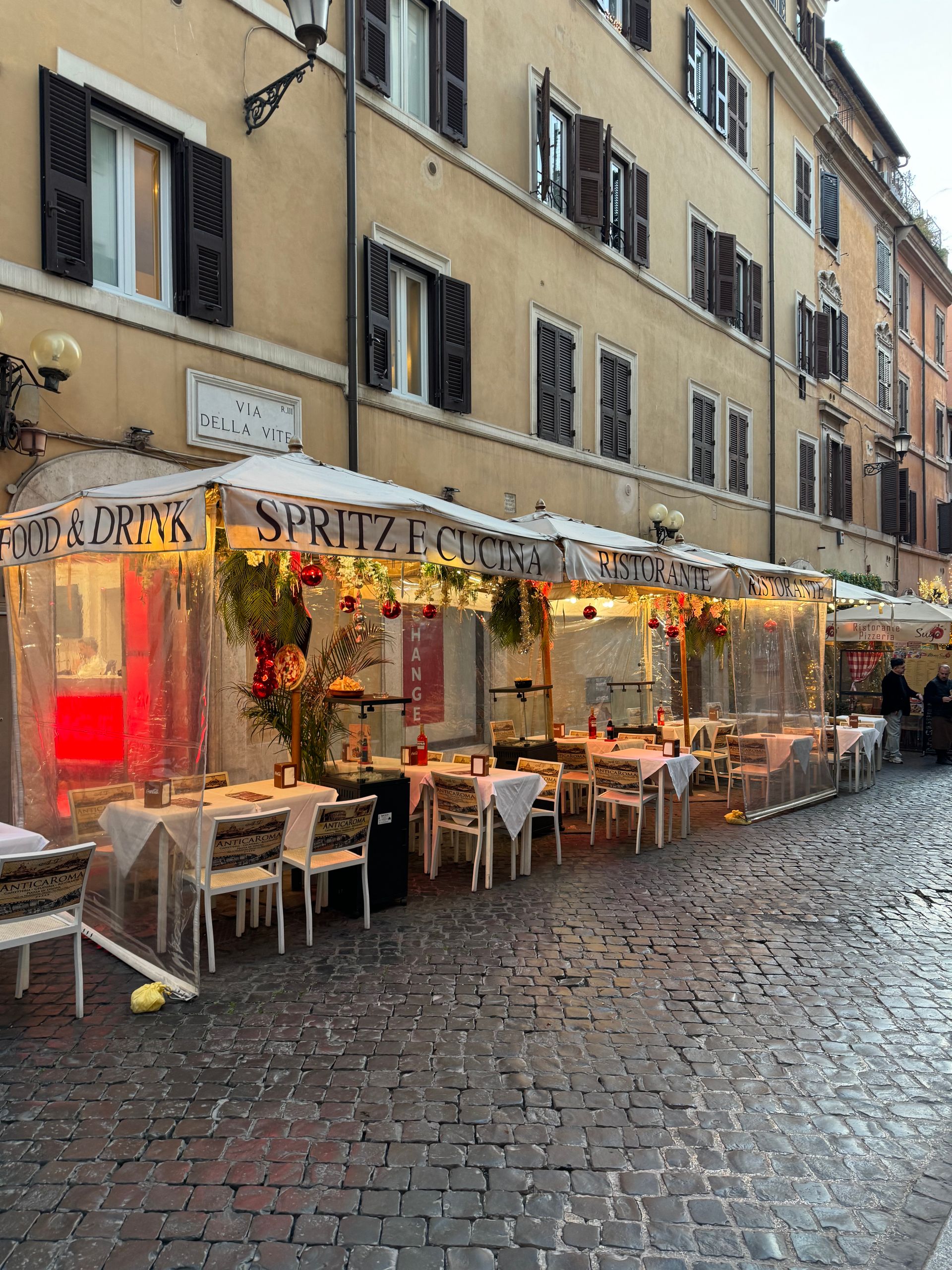 What Outdoor Dining Reveals About a Street - A cozy street-side cafe with al fresco dining in Rome, highlighting its charming architectural surroundings.