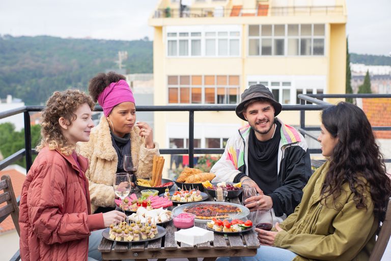 Why I Want More Meals With No Rush Attached - A group of friends enjoying a meal on a terrace in Portugal, capturing the essence of friendship and leisure.