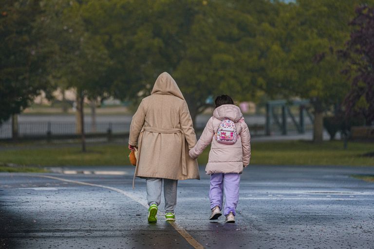 What School Mornings Teach About Community - A mother and daughter holding hands while walking on a path in Stamford, Connecticut.