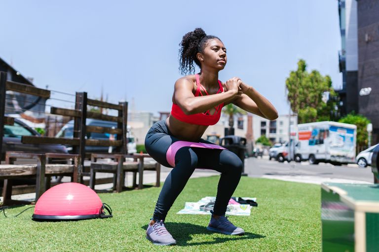 Black Women Fitness Focus Group - African American woman exercising with a resistance band outdoors.