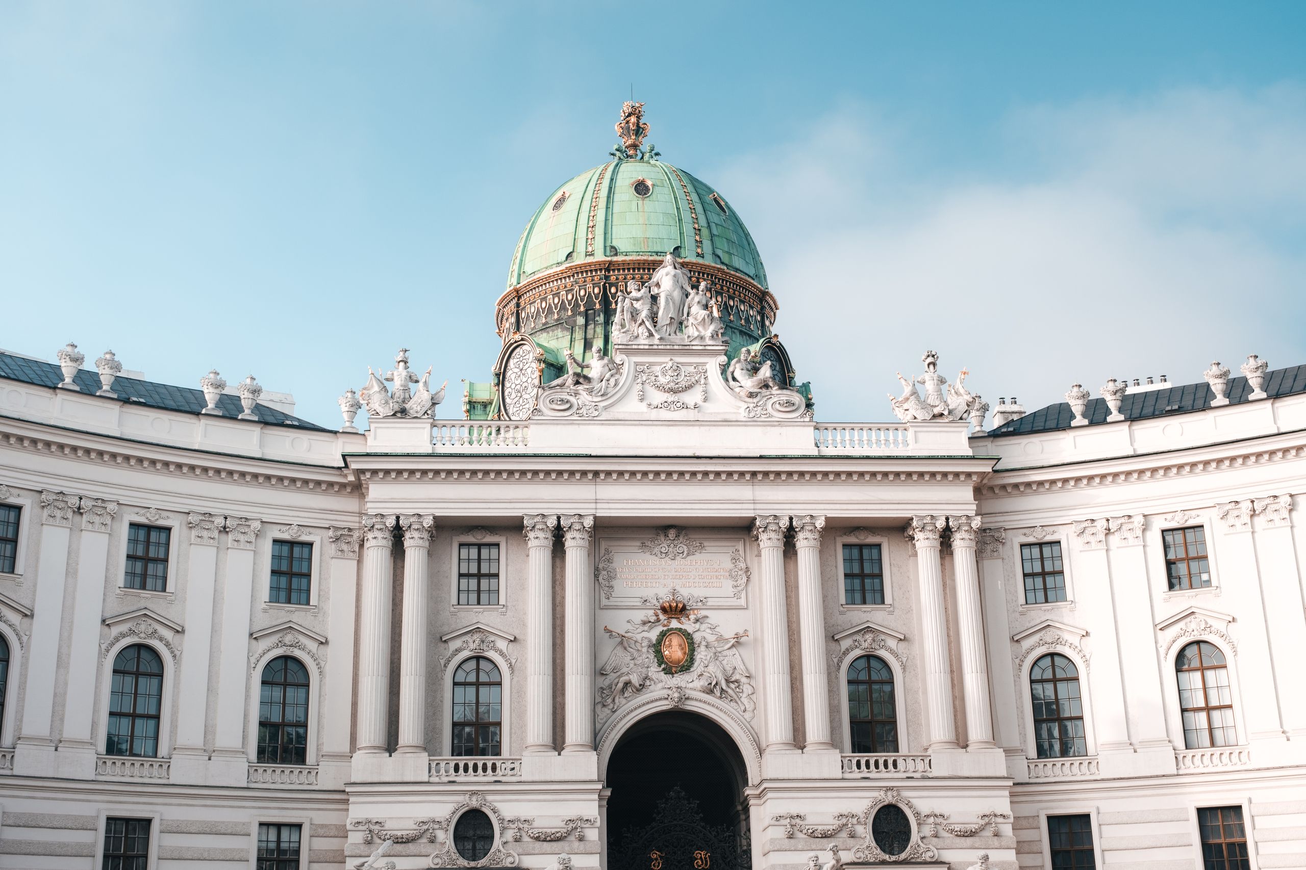 Austria Travel Guide - Elegant view of the Hofburg Palace's dome and facade in Vienna, Austria under a clear sky.