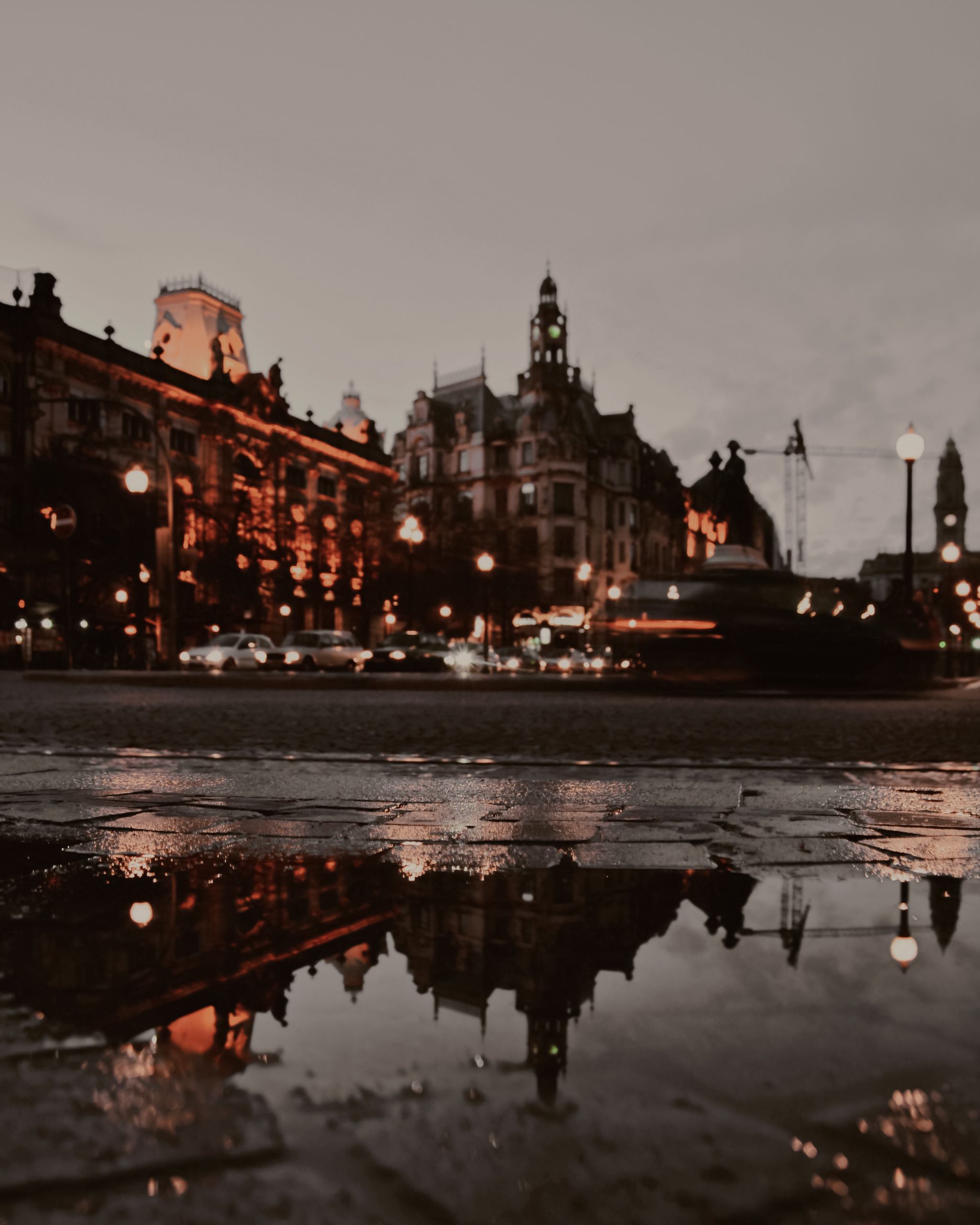 Beauty of a City After Rain - City street view at night with buildings and lights reflecting in puddles after rainfall.