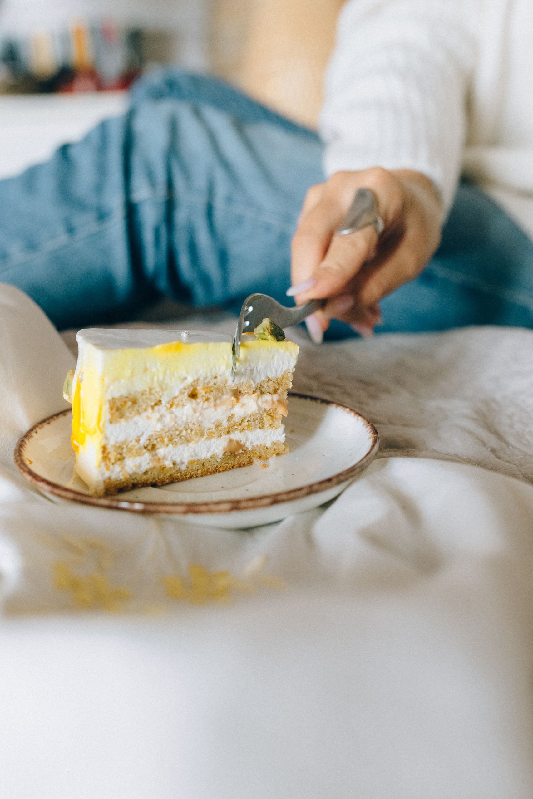 Cake Slice - A delightful lemon cake slice on a plate with a person taking a bite, emphasizing indulgence and taste.
