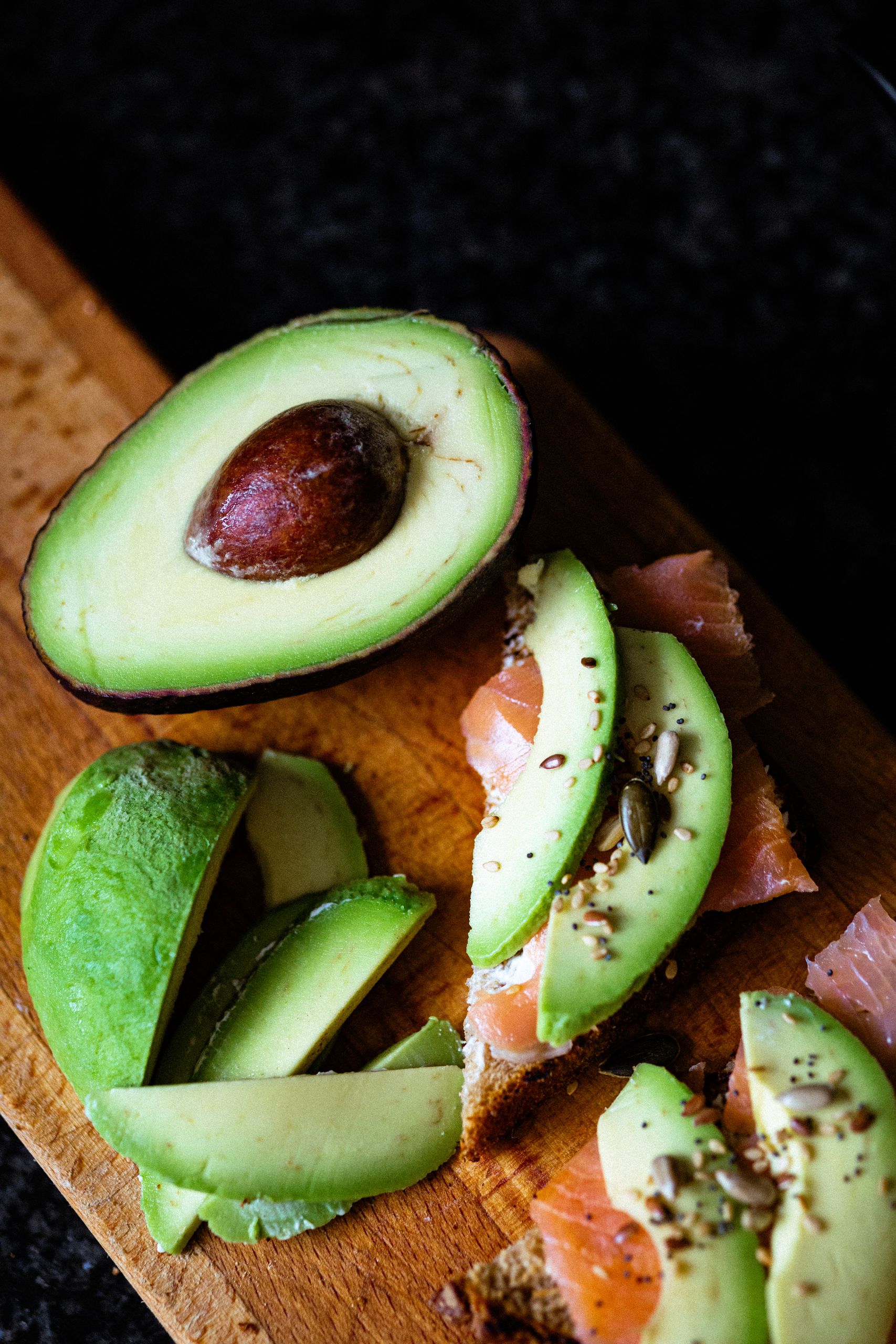 Fat Fast Keto Experiment: Day One Journal - Top view of fresh avocado and smoked salmon on a wooden cutting board.