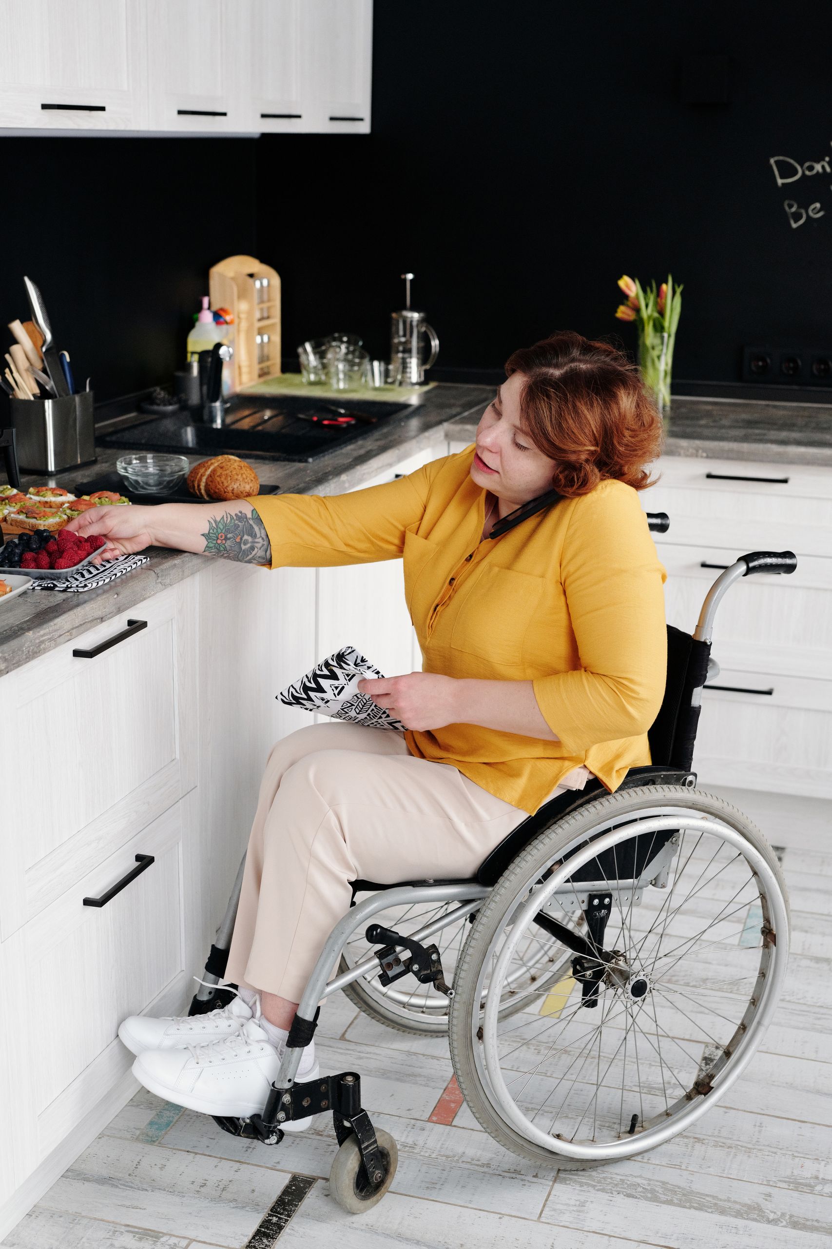 Hosting for Guests with Disabilities - Woman in a wheelchair engaging in daily activities at home, promoting inclusivity.