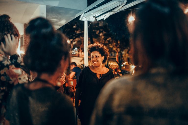 I Am Choosing Belonging Over Popularity - A cheerful woman enjoying a lively night out with friends at a bar. Captures joy and camaraderie.