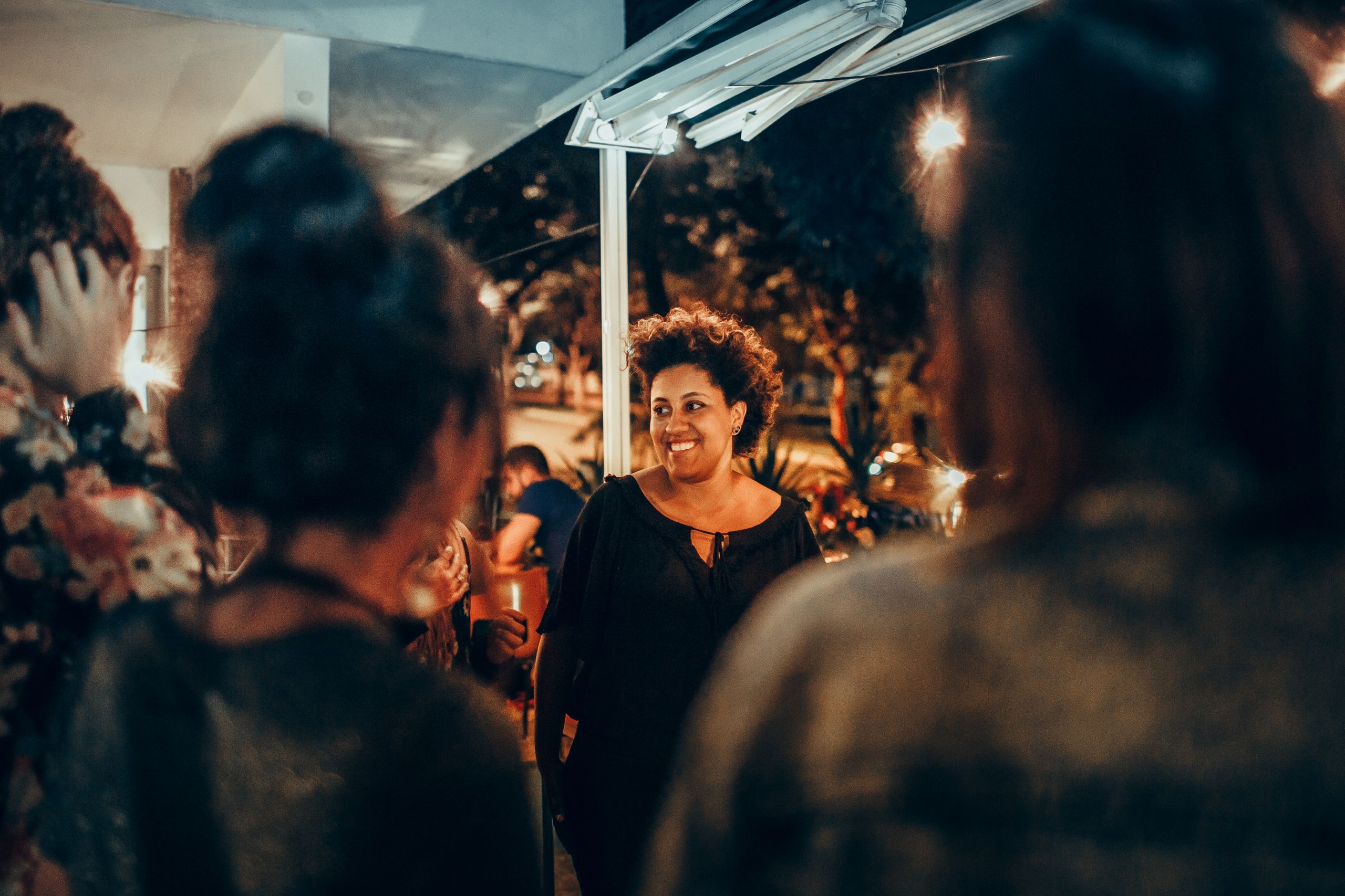 I Am Choosing Belonging Over Popularity - A cheerful woman enjoying a lively night out with friends at a bar. Captures joy and camaraderie.