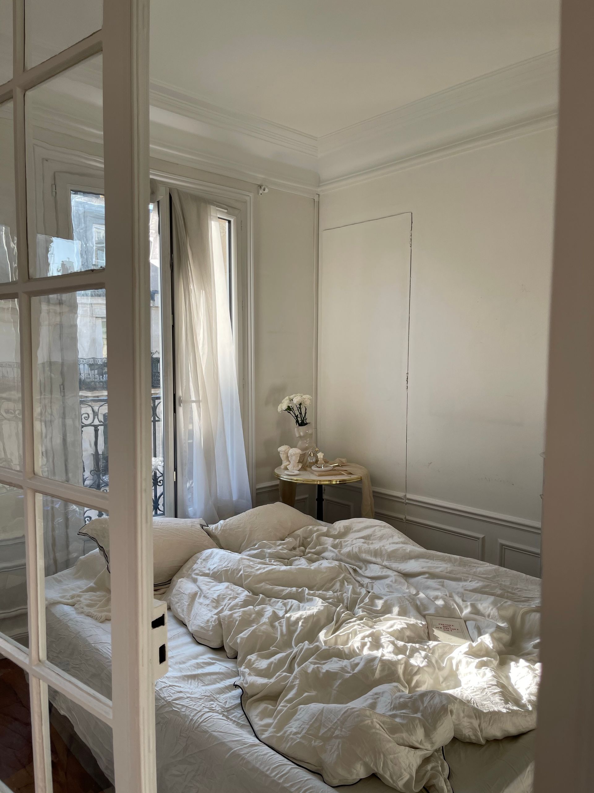 I Want a Life That Looks Used - Bright and airy bedroom with sunlight streaming through the window, featuring white bedding.