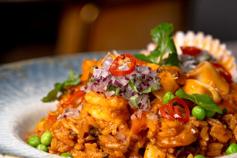 Ignite Your Taste Buds: Celebrating International Hot & Spicy Food Day Across the USA - A mouth-watering spicy shrimp fried rice garnished with herbs and vegetables, perfect for food lovers.
