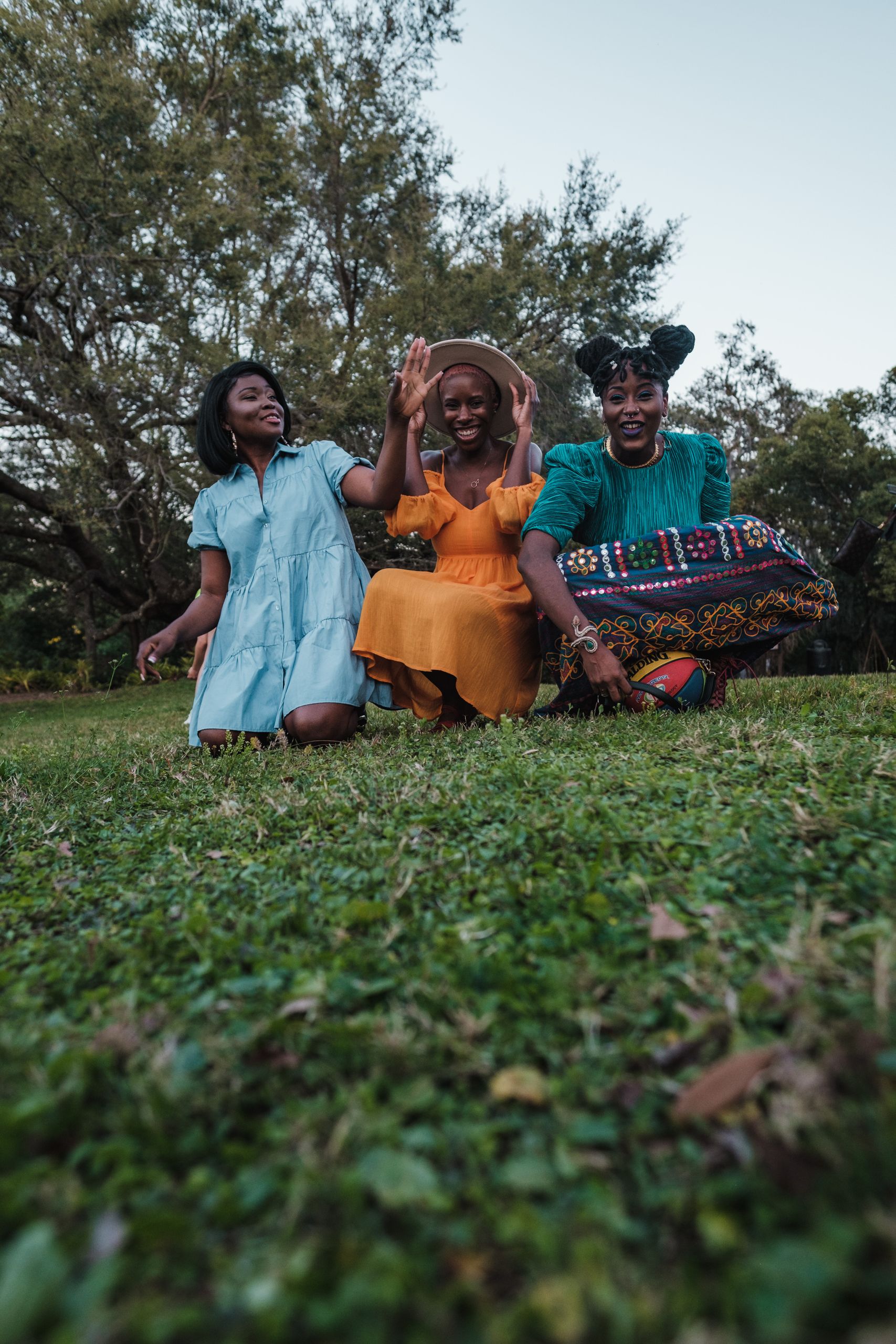 Living Out Loud Is A Daily Practice - Three friends enjoying a fun and happy day together outdoors in a grassy park.