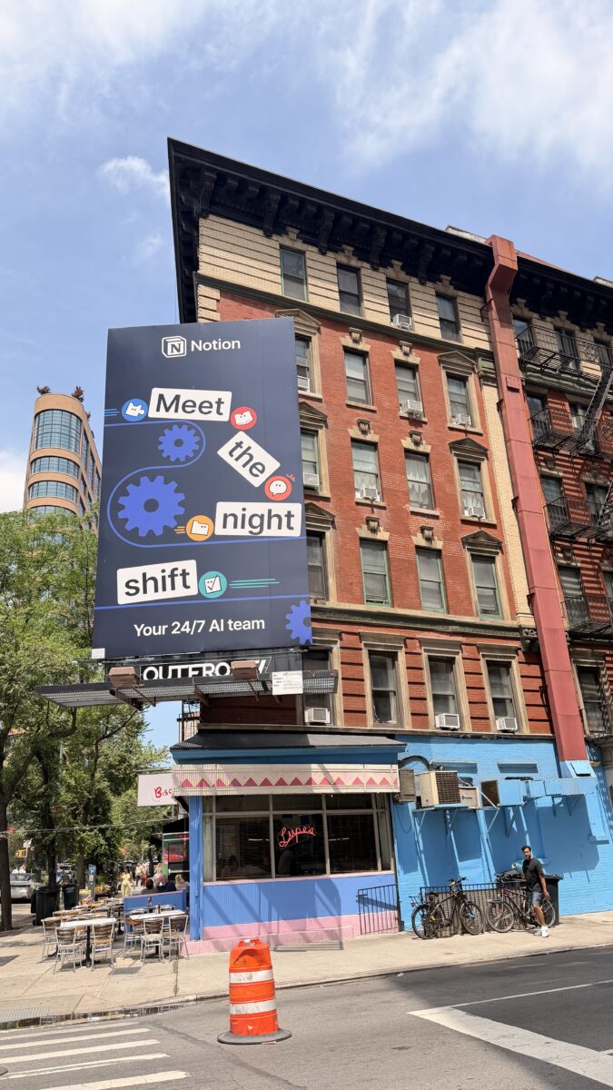 Notion billboard above a colorful restaurant in New York City
