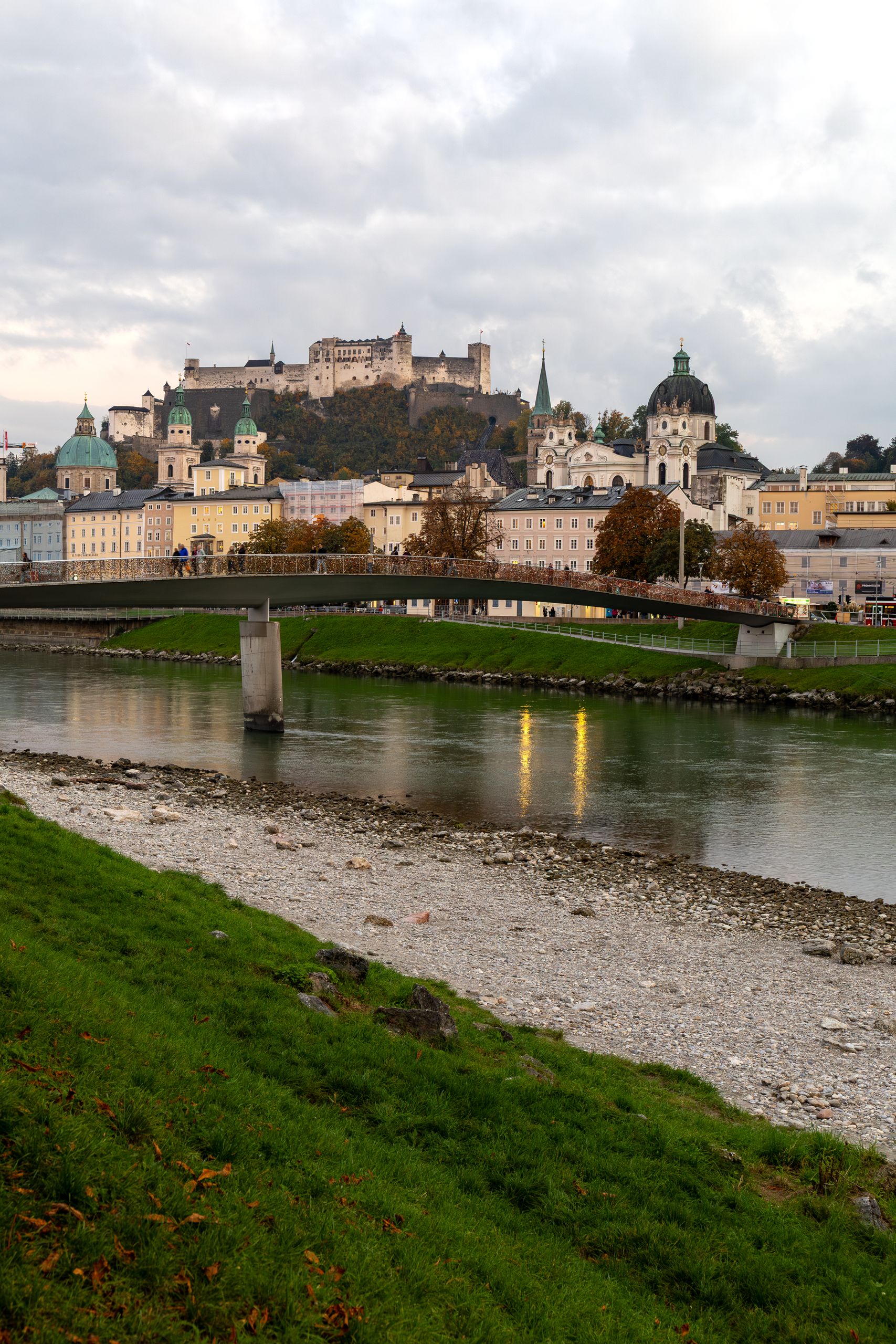 Sound of Music -Picturesque autumn landscape in Salzburg featuring historic castle, river, and vibrant fall foliage.