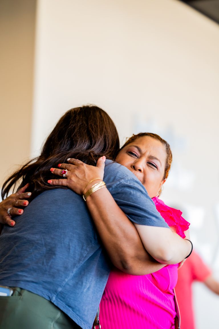 Practical Gratitude Begins Where Appreciation Becomes Action - Two adults sharing a heartfelt embrace in a warmly lit indoor setting, highlighting connection.